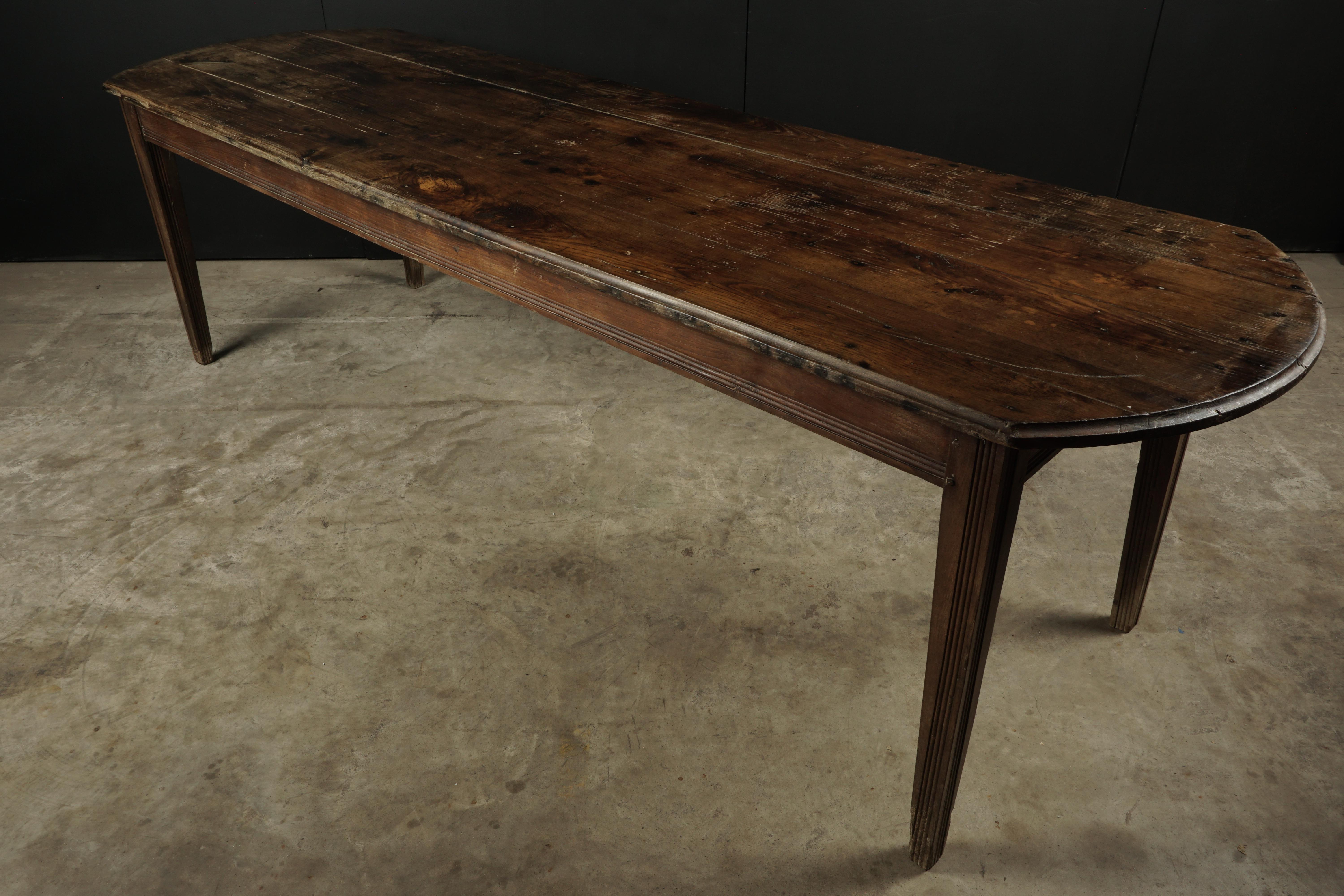 Large farm table from France, circa 1930. Solid pine construction with tapered feet. Great patina.