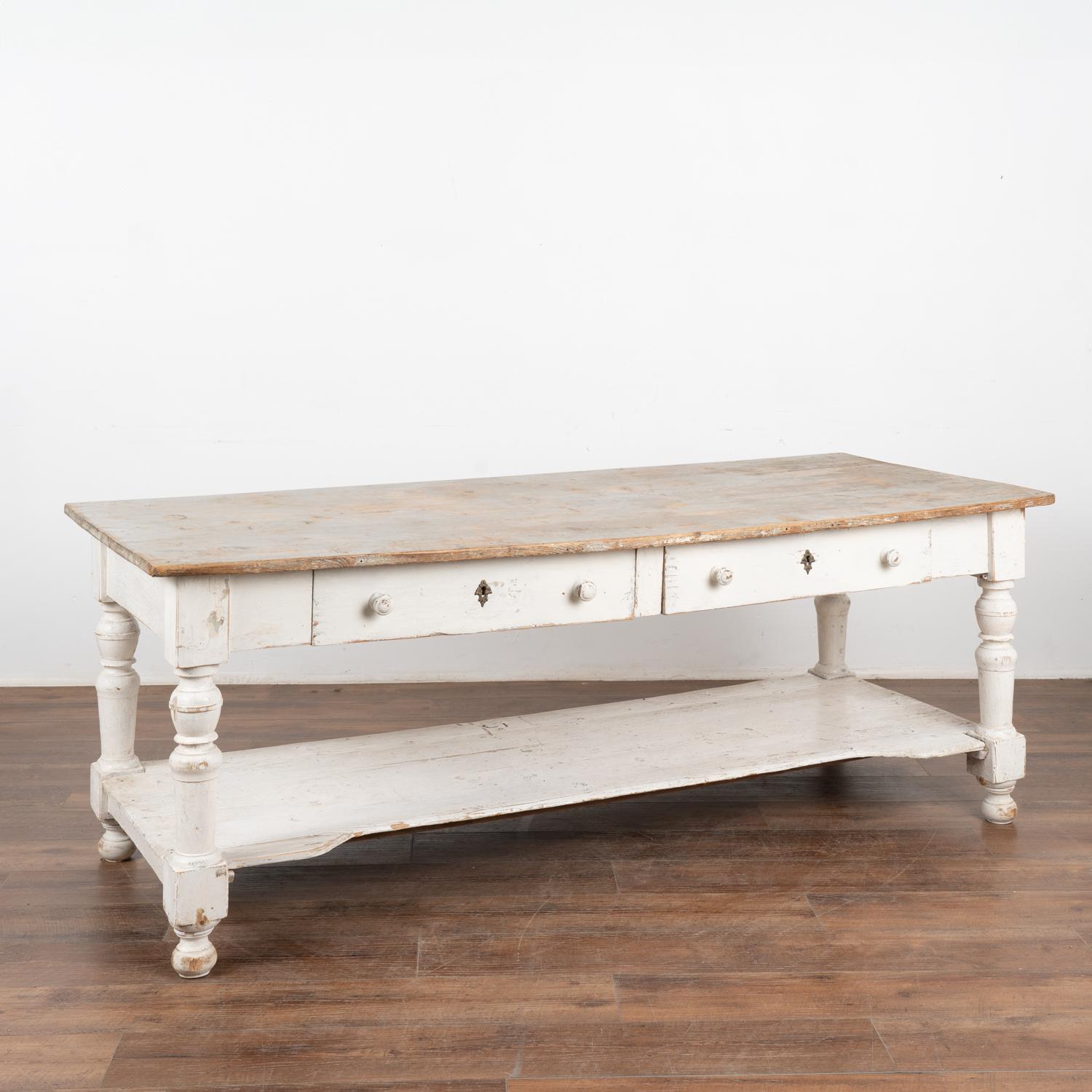 It is the years of use that fill this white painted work table with character and purpose. At 6.5' long with a lower shelf and two large drawers it is ideal for a modern kitchen island.
The gray painted top reveals generations of use in the