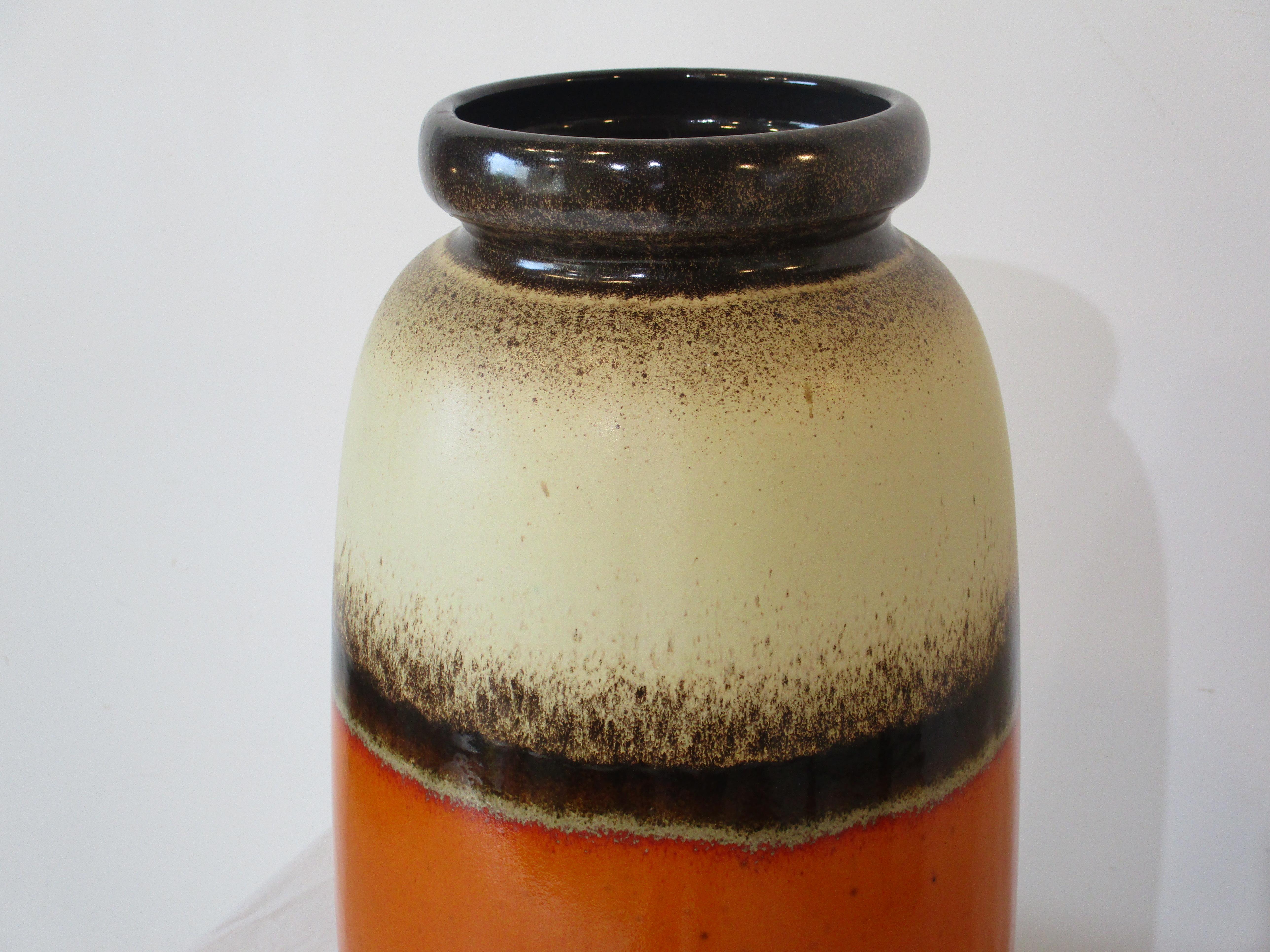 A very large Fat Lava ceramic pottery vase with a tan body having brown, dark brown and a orange glaze to the middle. Fine splatter affect to the edges and the colors give this piece a great Mid Century vibe. Crafted in Germay by Scheurich.