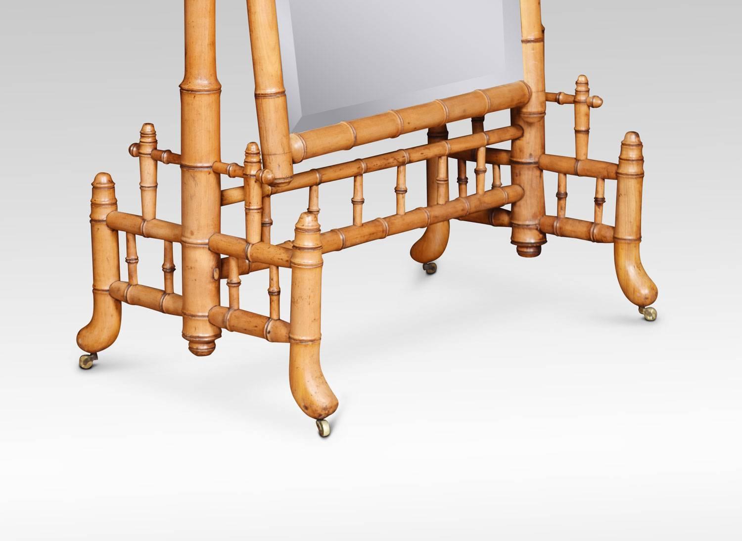 A large cheval mirror framed in faux bamboo, the original bevelled mirror plate and curved top corners in the style of Louis Philippe. Elm wood has been turned and stained to closely resemble bamboo, trimming out the mirror and framing it with two