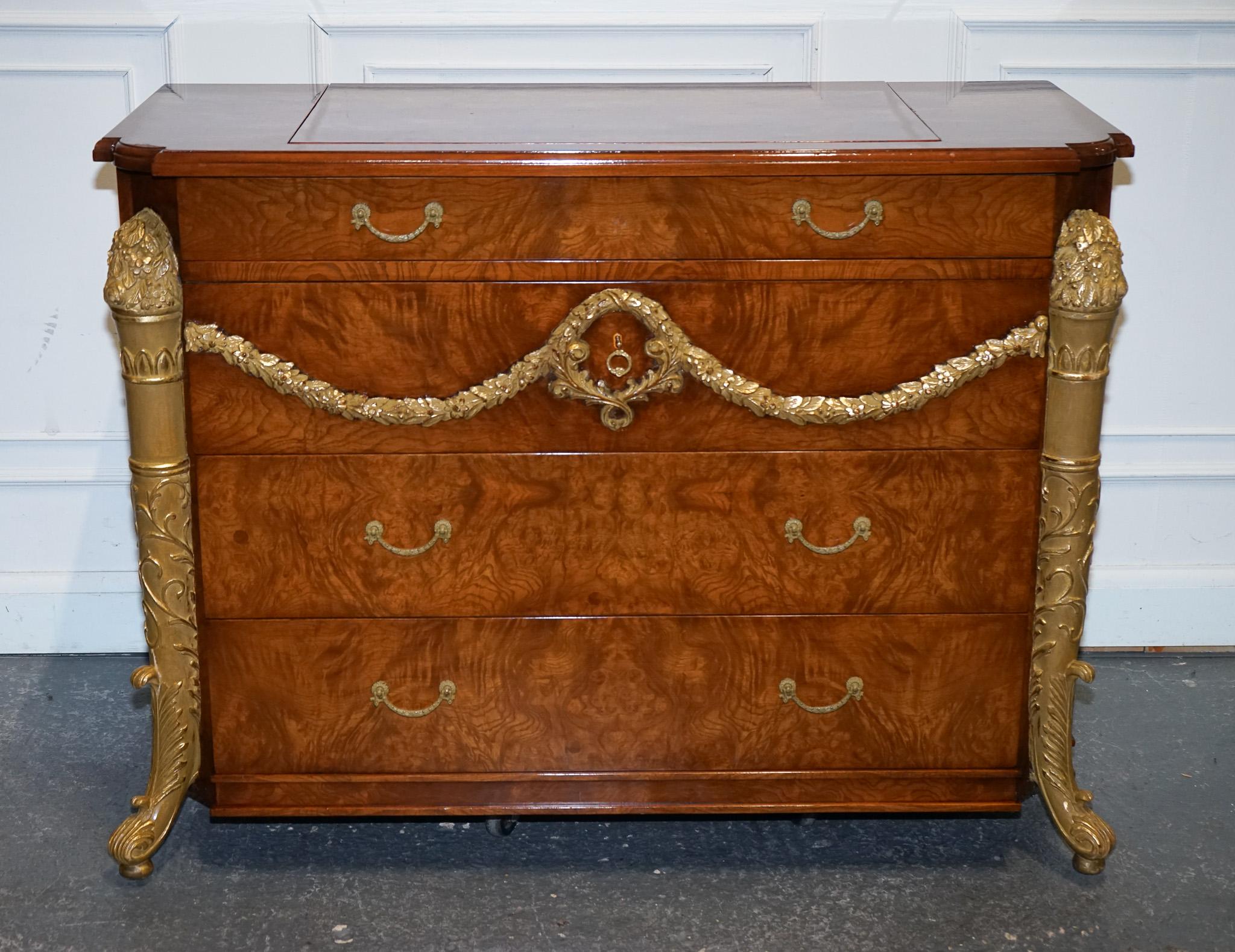 
Antiquariato di Londra

Un'impressionante cassettiera in stile Regency, splendidamente dettagliata con colonne d'acanto dorate e motivi di ghirlande ornamentali, realizzata con una finitura lucida. Questo elegante pezzo è stato adattato su misura