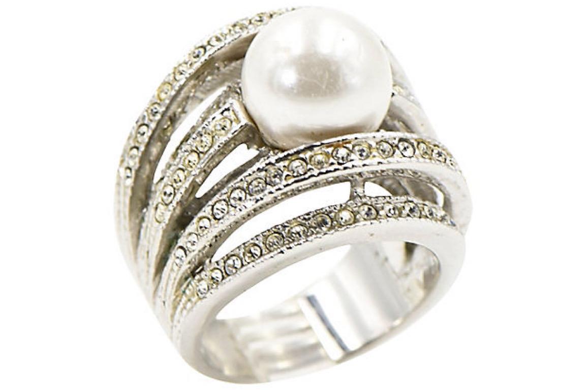 Impressive three dimensional cocktail statement ring featuring 7 rows of bands filled with crystals mounted at different heights to create a fantastic design. In the center of the band is a costume 11mm pearl. The ring is made of sterling silver and