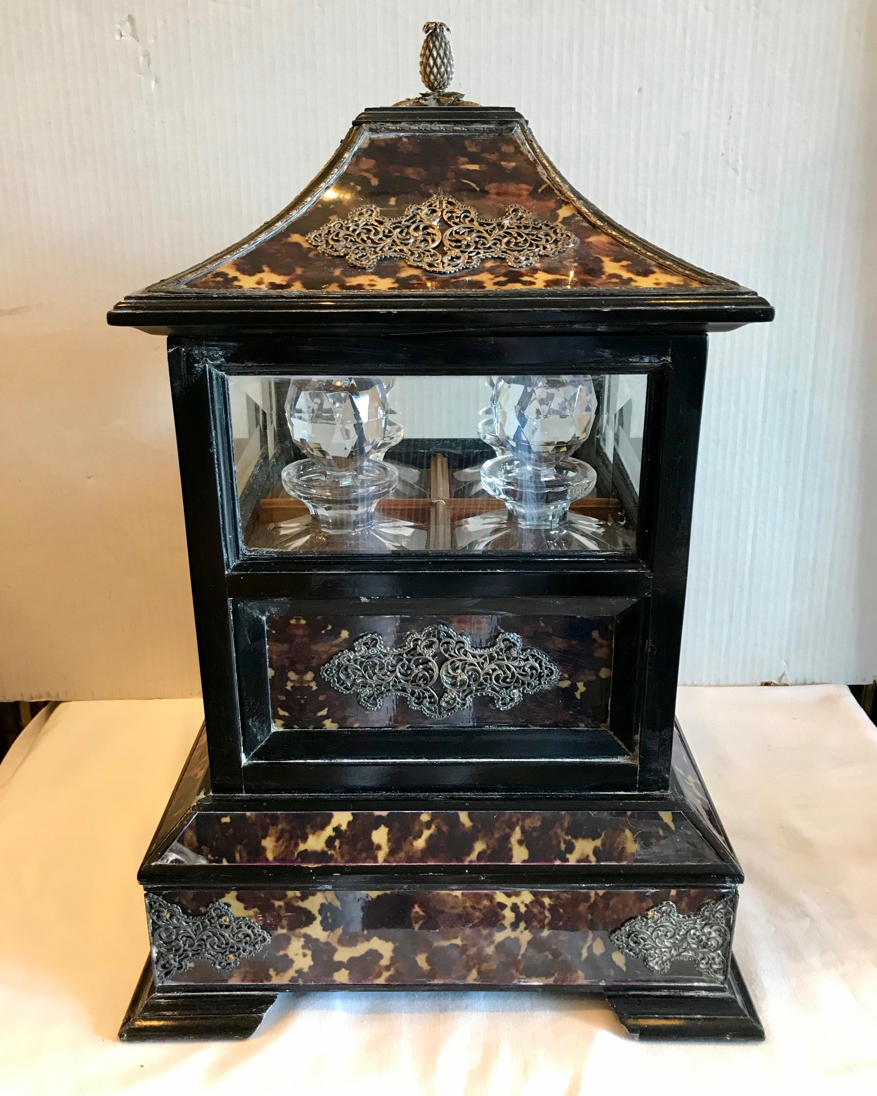 Dramatic in scale and proportion and fitted with 4 fine decanters in the style of Maitland Smith. The cellarette is further decorated with silvered filigree 
applied accents.
Stellar quality