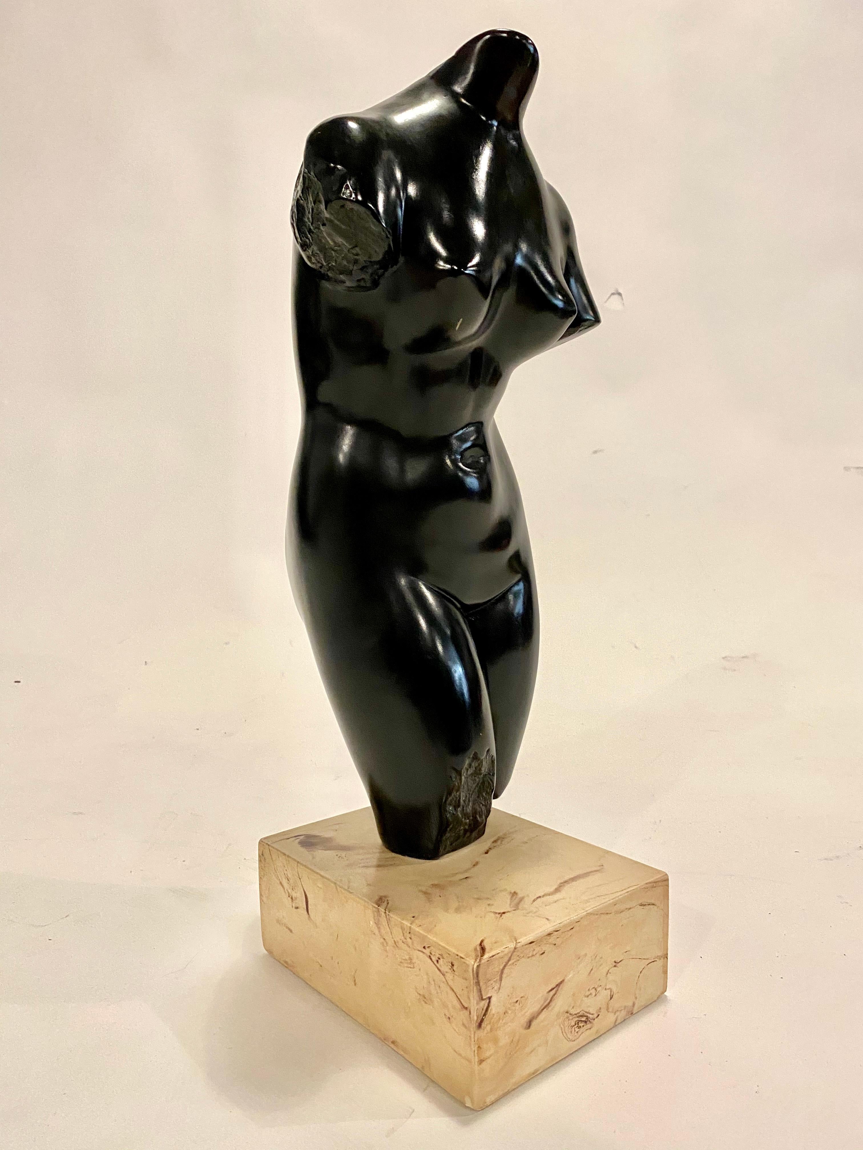 Large midcentury female torso sculpture made of black cast stone and a cream color marble plinth by Alva Studios, 1960s. Stamped on bottom leg.