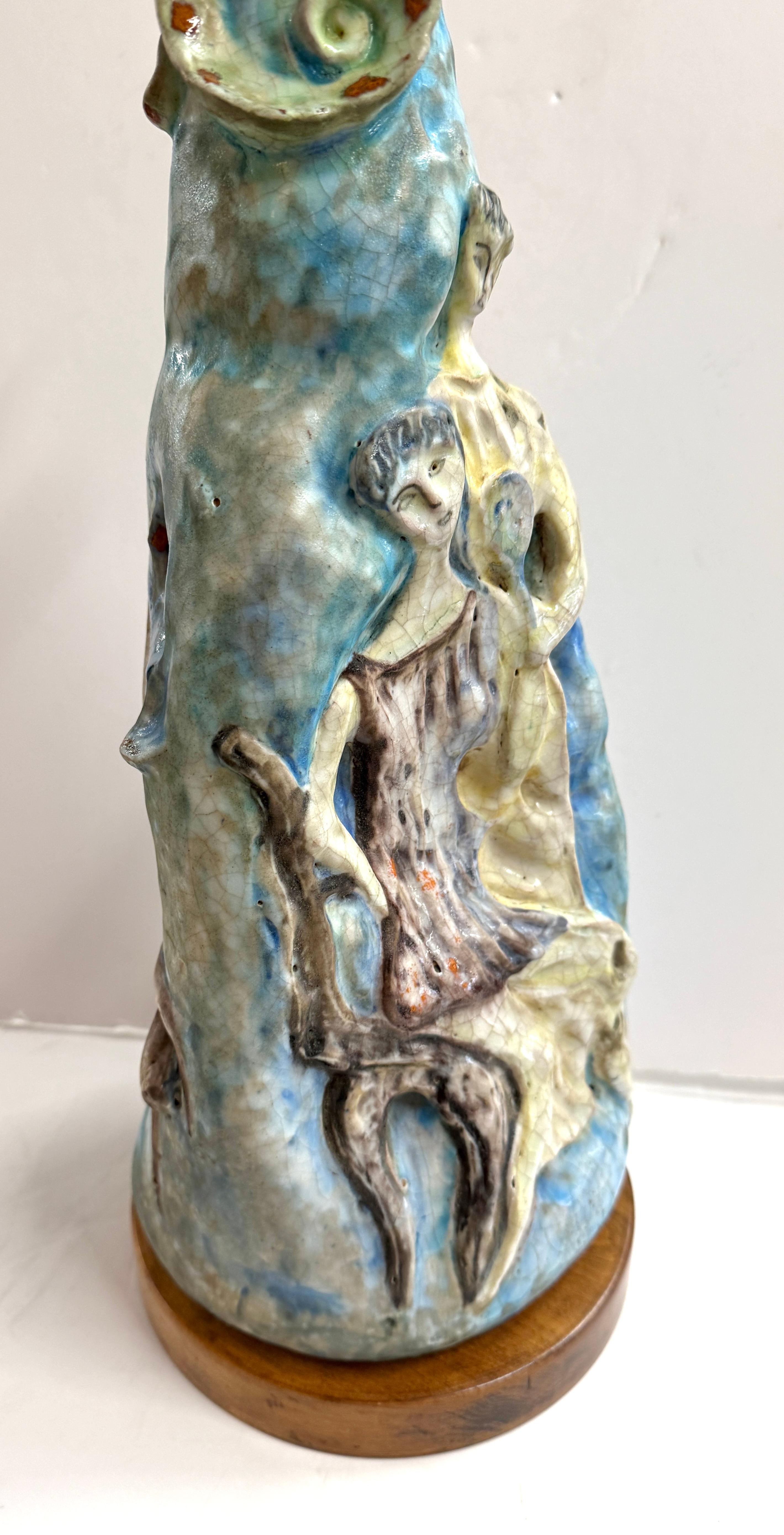 A beautiful molded figural lamp by Fantoni sculpted out of pottery. It is affixed to a wooden base. The lamp has just been rewired and is working well. We are not including a shade as they are more costly to ship than acquire locally. 
The lamps is