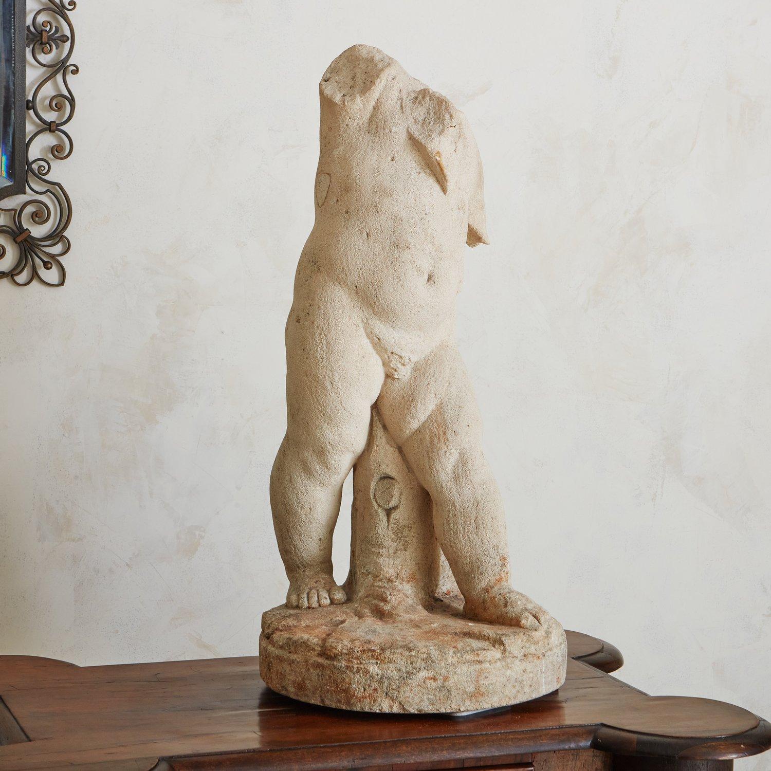 A vintage hand carved figural limestone sculpture on a circular base. We love the weathered patina and realistic detailing on this beauty. It would look fabulous in a garden, entryway or on a patio. Sourced in France, Late 20th Century.