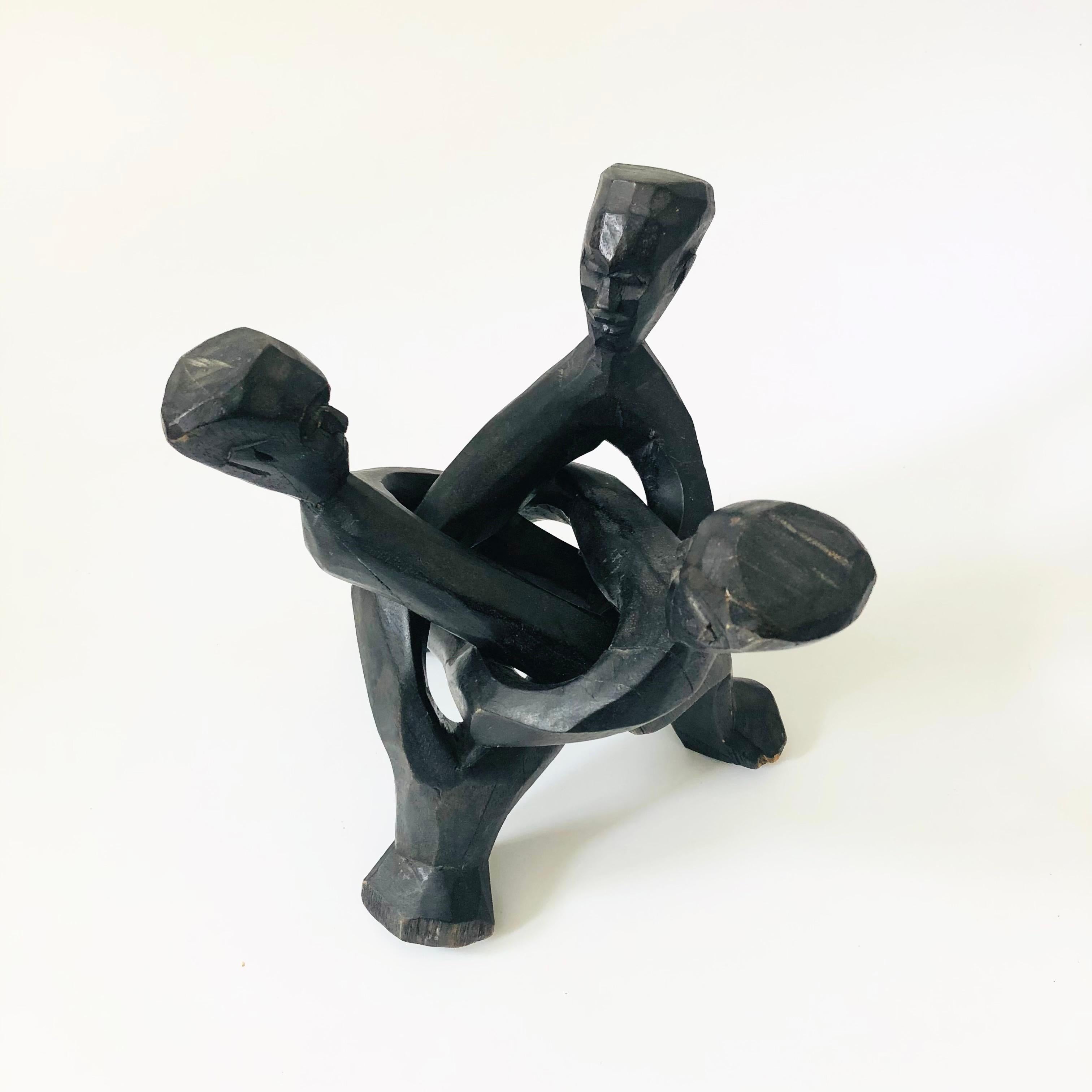 Un grande cavalletto pieghevole in legno intagliato d'epoca. A forma di treppiede con persone scolpite per ogni gamba. Di dimensioni più grandi, è perfetto per essere utilizzato come supporto per piante, per contenere una ciotola o per esporre un