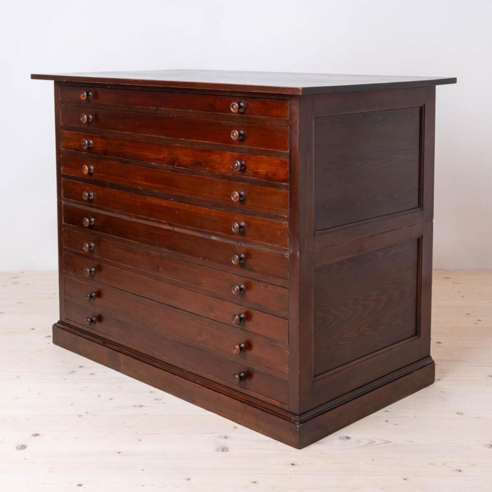 This large two-part filing or drawing cabinet  was made around early 20th century. It is made of pine wood that was stained to a darker color and has been gently refreshed, preserving original patina and traces of time. Appears with age related