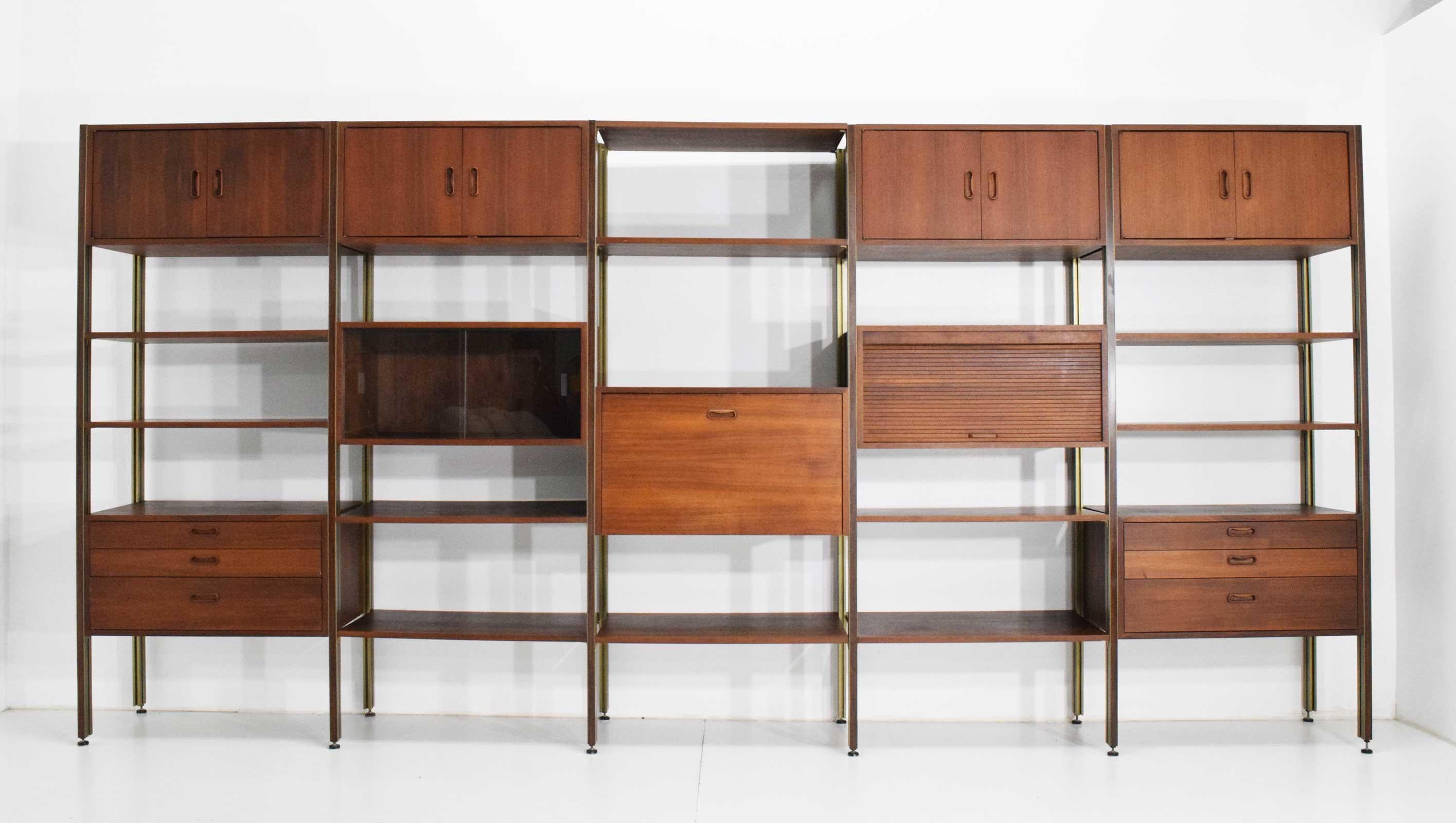 This is a beautiful Omni bookcase and storage system by George Nelson for Structural Products. Unit is walnut with bronze support poles that have inlaid wood. Unit has four cabinets with dual doors, one cabinet with sliding glass doors, two cabinets
