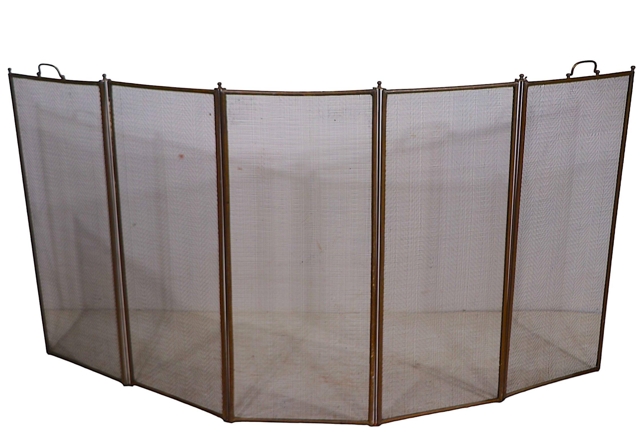 Hard to find five fold spark gard,  fireplace screen, having a brass frame with metal mesh screen panels. The screen is in very good, clean, original, ready to use condition, showing only light cosmetic wear, normal and consistent with age. 
