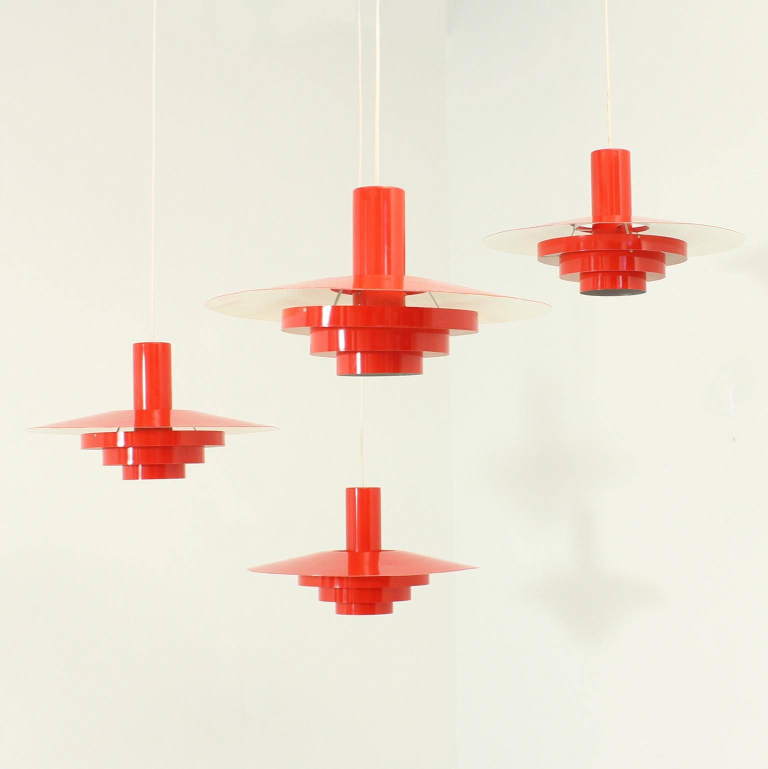 Four Falcon pendant lamps designed by Andreas Hansen in 1967 for Fog & Morup, Denmark. Large model in red lacquered aluminum.