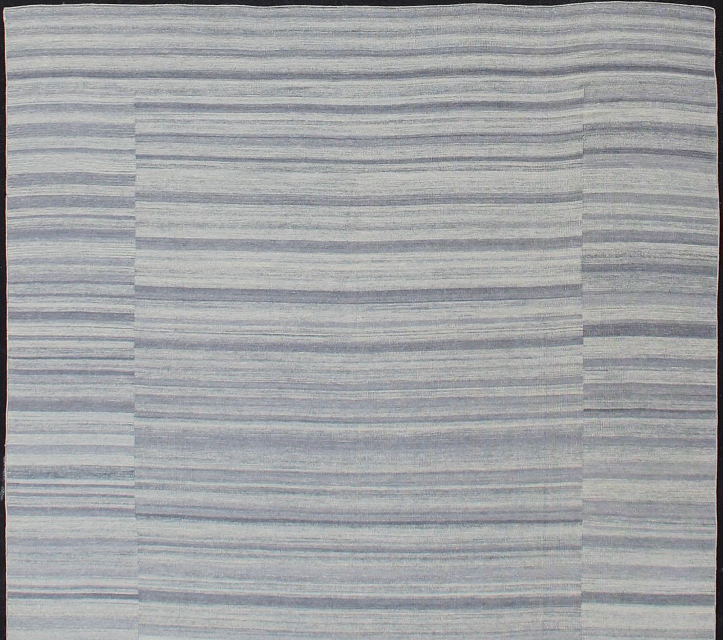 Tappeto kilim casual dal design moderno, tappeto kilim con disegno a strisce in blu e grigio tenui, tappeto OB-103715358-6018007, Paese d'origine/tipo: India / Kilim

Questo tappeto moderno e casual presenta un design a righe e una trama a tessitura