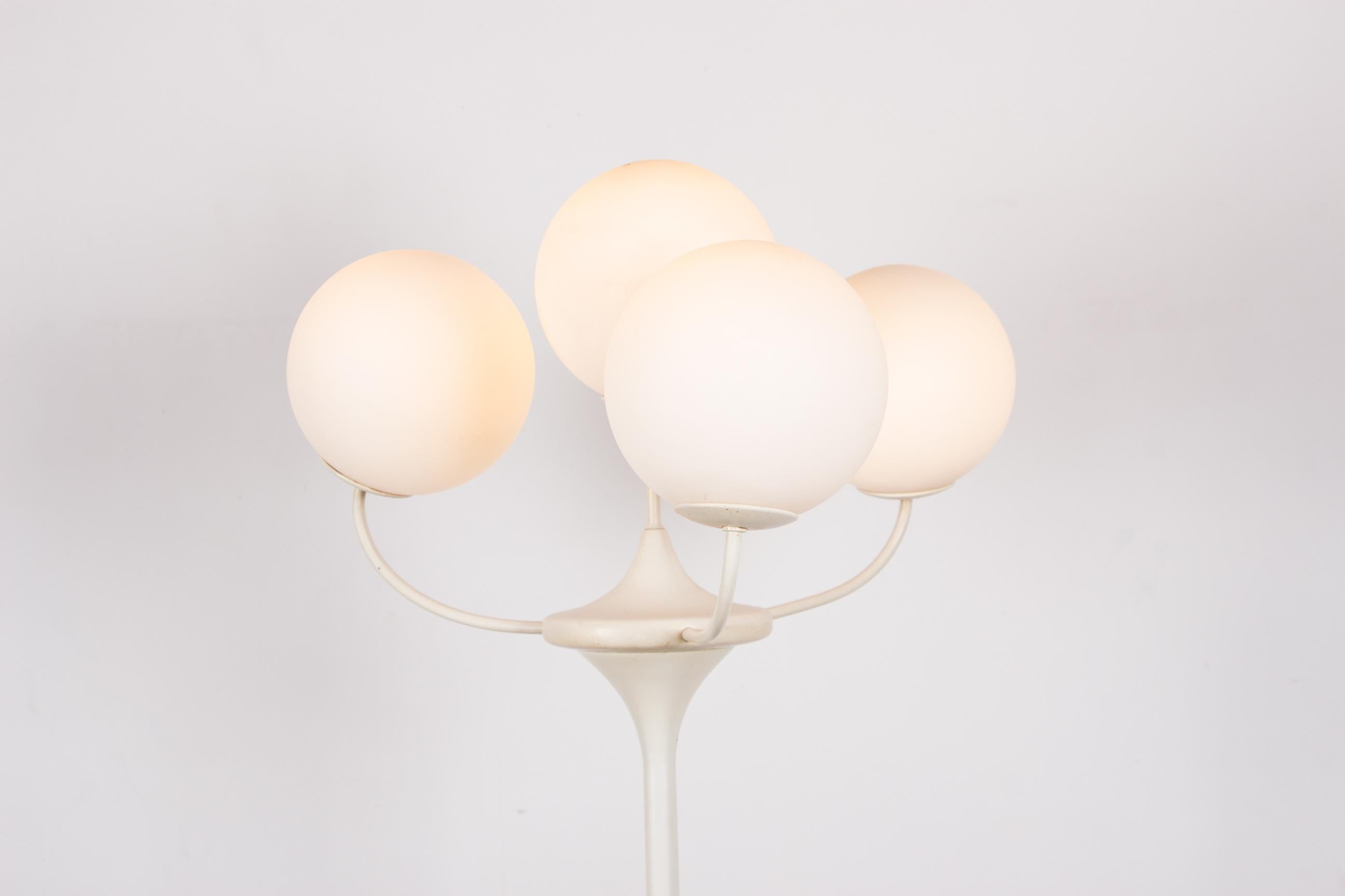 Superbe grand lampadaire dans l'esprit NO AGE ou scandinave. 
Les 4 globes blancs et ronds s'ouvrent en collier et sont complétés par la base tulipe, le tout offrant un design raffiné très aérien. 
Fabrication de très belle facture, lumière discrète