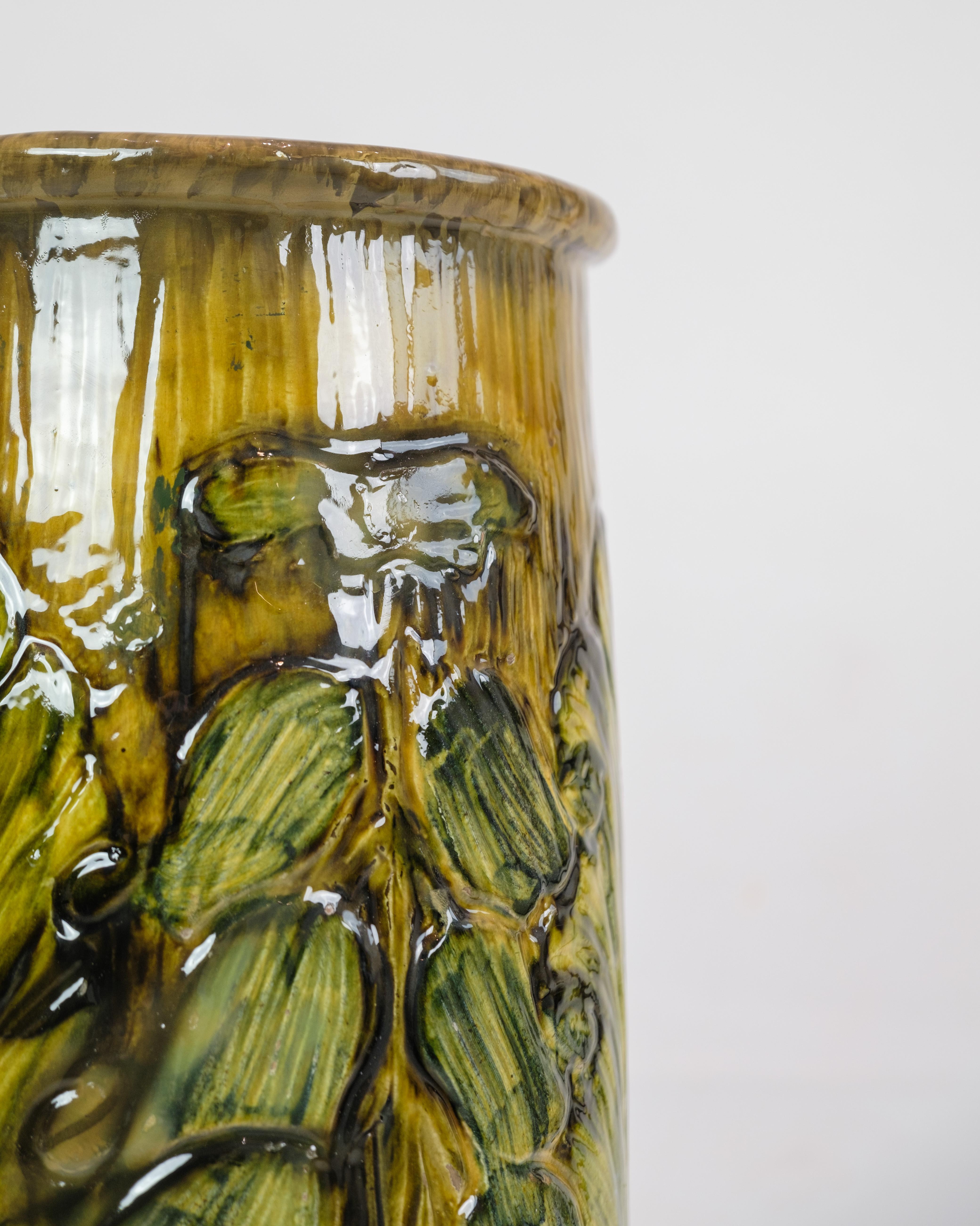 Diese große Bodenvase aus Danico-Keramik ist ein bemerkenswertes Stück aus den 1960er Jahren. Die Vase mit ihrer Mischung aus gelben und grünlichen Farben strahlt eine einzigartige und lebendige Ästhetik aus, die für diese Epoche charakteristisch
