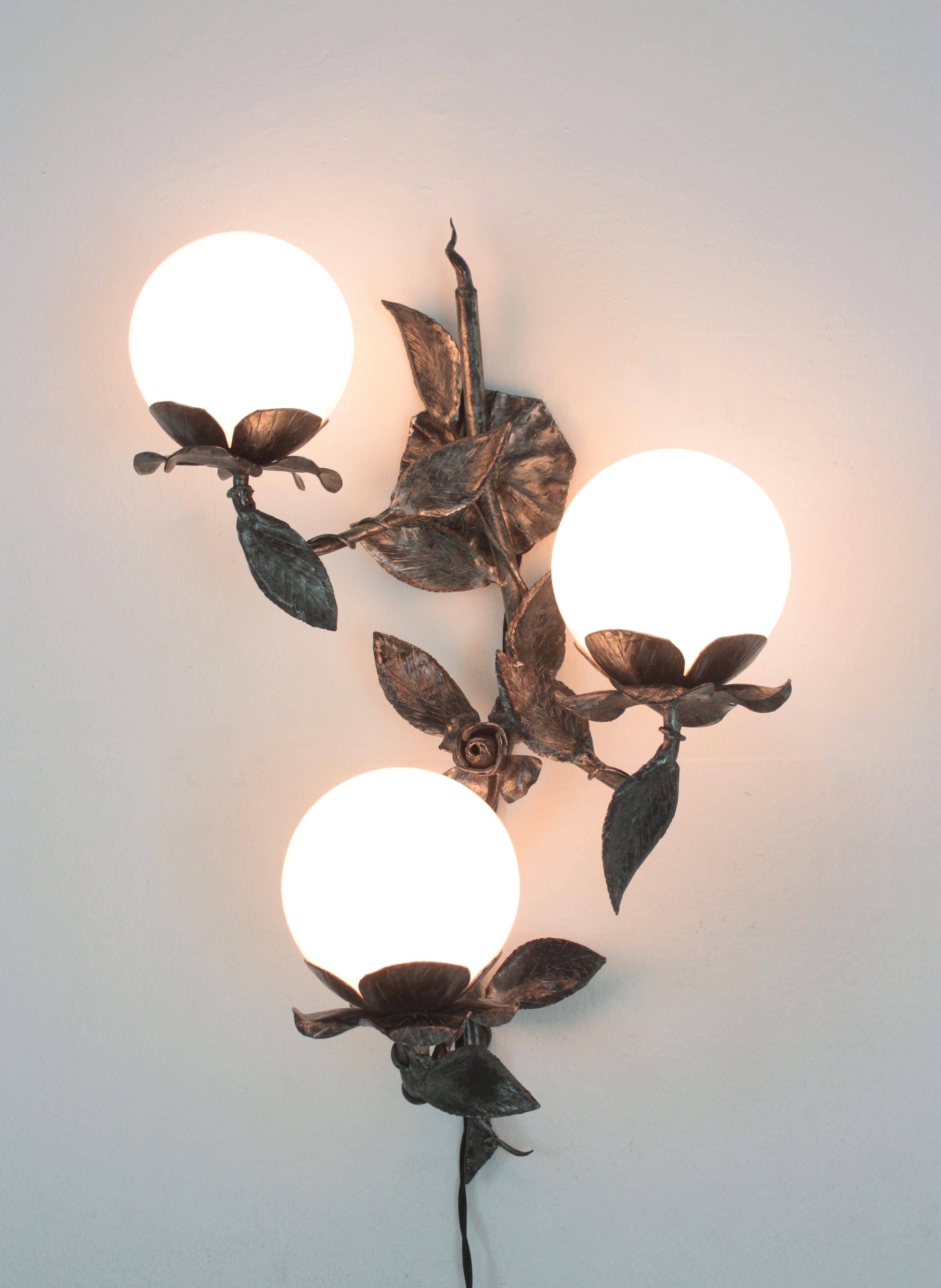 
Midcentury Foliage Floral Three-Light Wall Sconce in Wrought Iron with Milk Glass Globes
Three-light wall sconce with opaline glass globe shades and naturalistic design, Spain, 1940s.
This wall light is entirely made by hand patinated iron. 
Richly