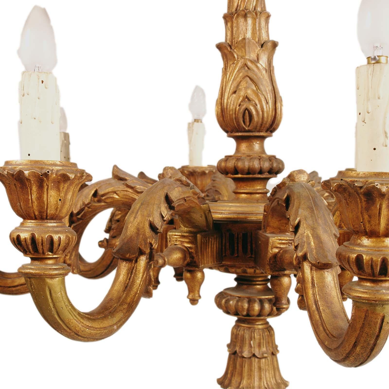 Large and majestic Florentine baroque chandelier in wood, gold leaf, hand carved walnut, with 9 lights.
This precious chandelier was from the Della Torre family dining room. 

History , curiosity and provenance of this item: 
Dining room from the