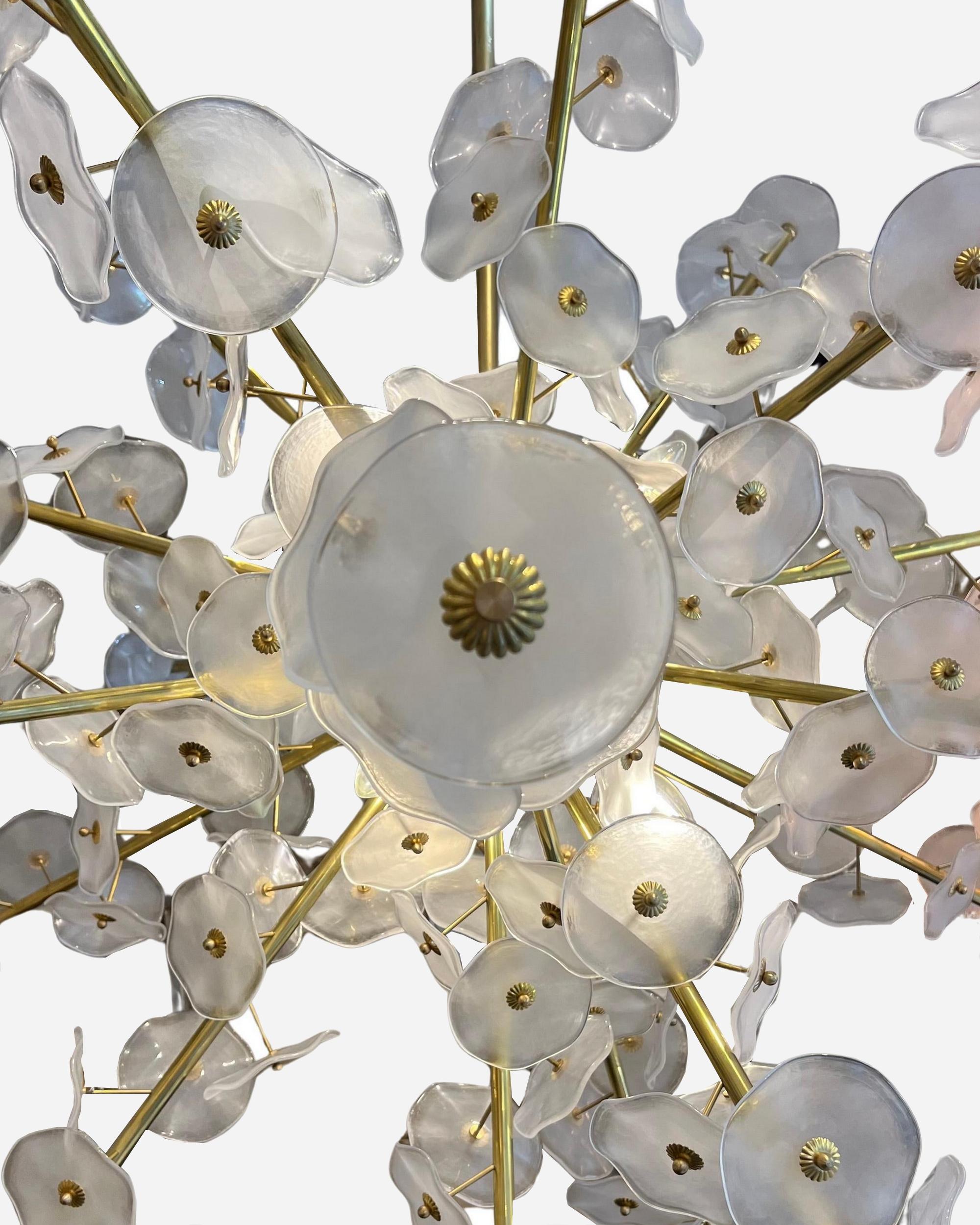 Large “flowers” chandelier. Murano Italy circa 1980.
Brass structure supporting a multitude of white and transparent Murano glass flowers, hand-worked and hot-formed.
Diameter: 140 cm
Current height: 67 inches, but it is possible to shorten the