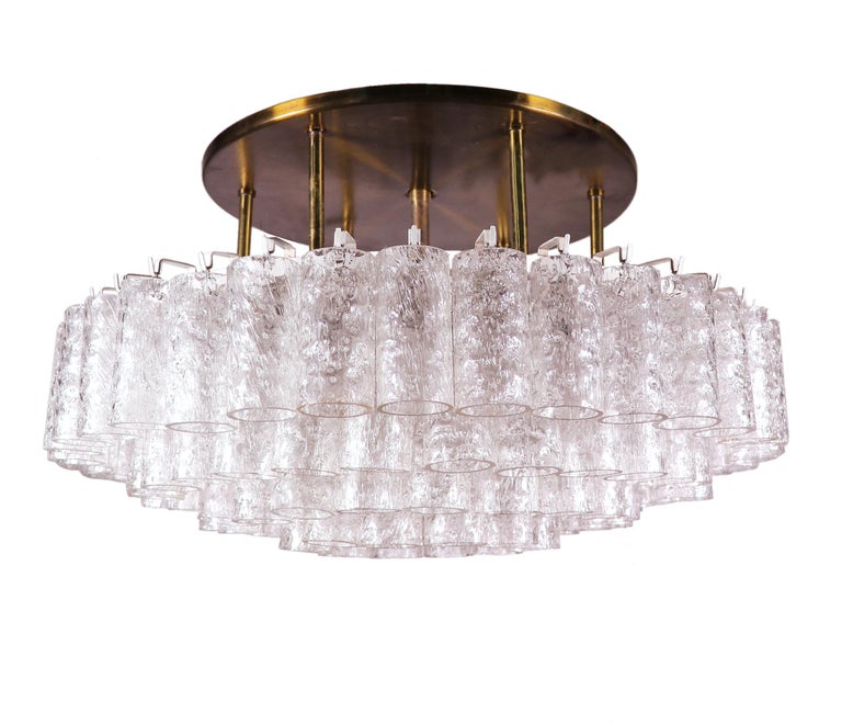 Large flush mount chandelier with 97 Murano glass tubes made by Doria Lighting, Germany in the 1960s. 

Style: mid century, modernist. 
Materials: glass and brass. 
Lighting: the lamp takes eight small E14 base Edison screw bulbs and one large
