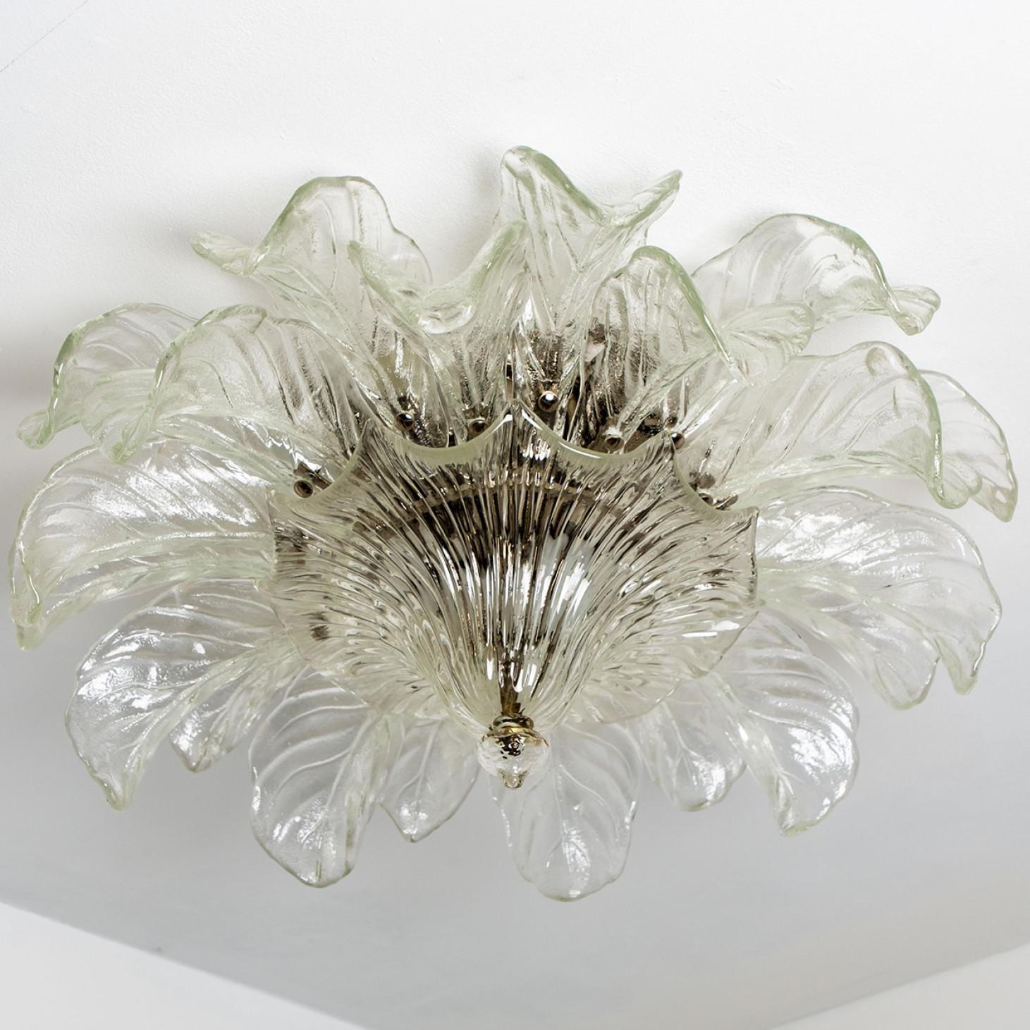 A large elegant flush mount, made of hand blown Murano glass by Barovier & Toso, Italy around 1960. The light has the shape of a flower with thick clear glass leaves and a chrome base and details. The glass leaves refract the light beautifully. The