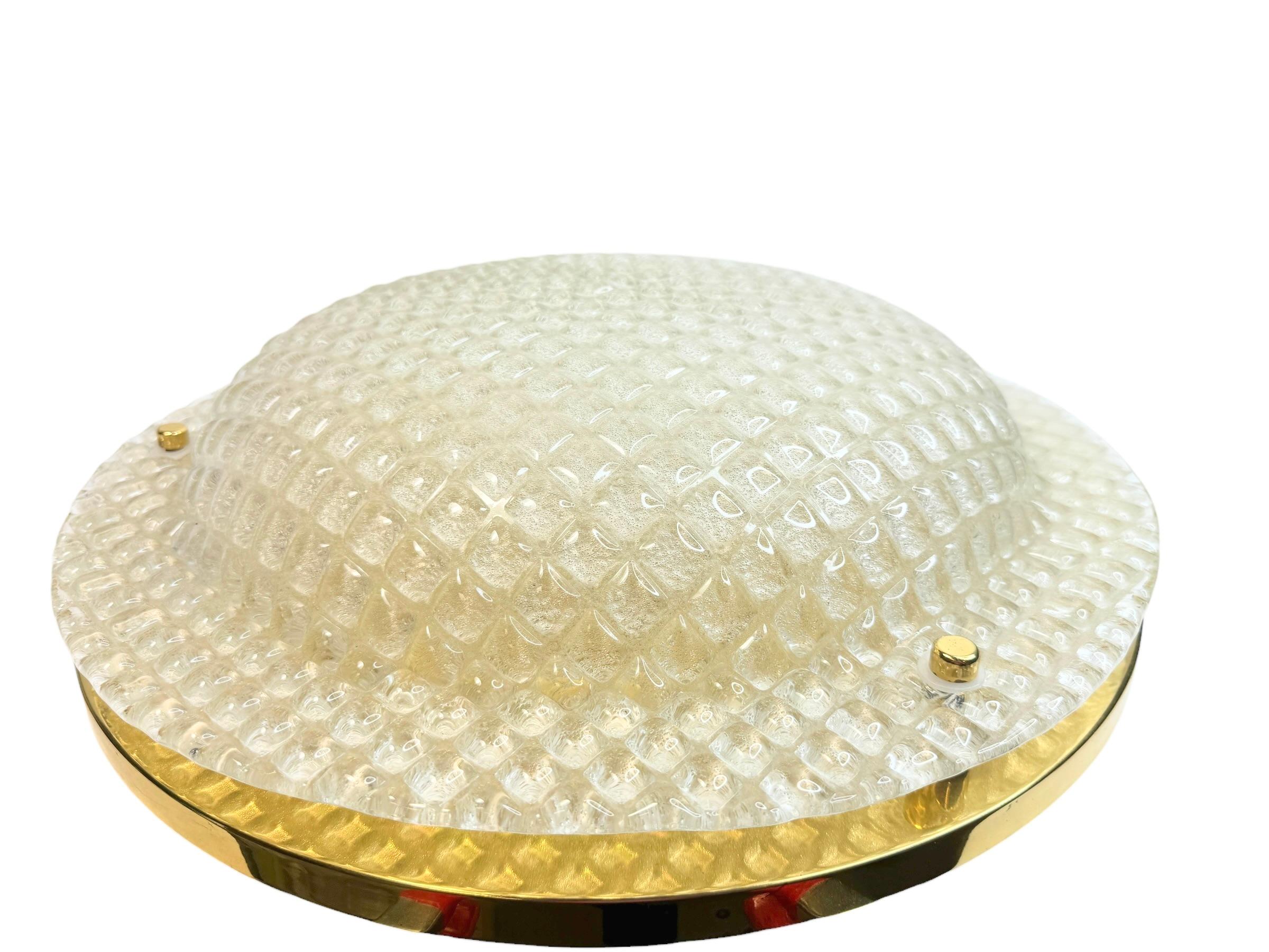 A beautiful large flush mount by German manufacturer Fischer Leuchten. The heavy glass element is supported by a polished brass plate with three light sources. Beautiful honeycomb style clear glass on a metal fixture. The Fixture requires three