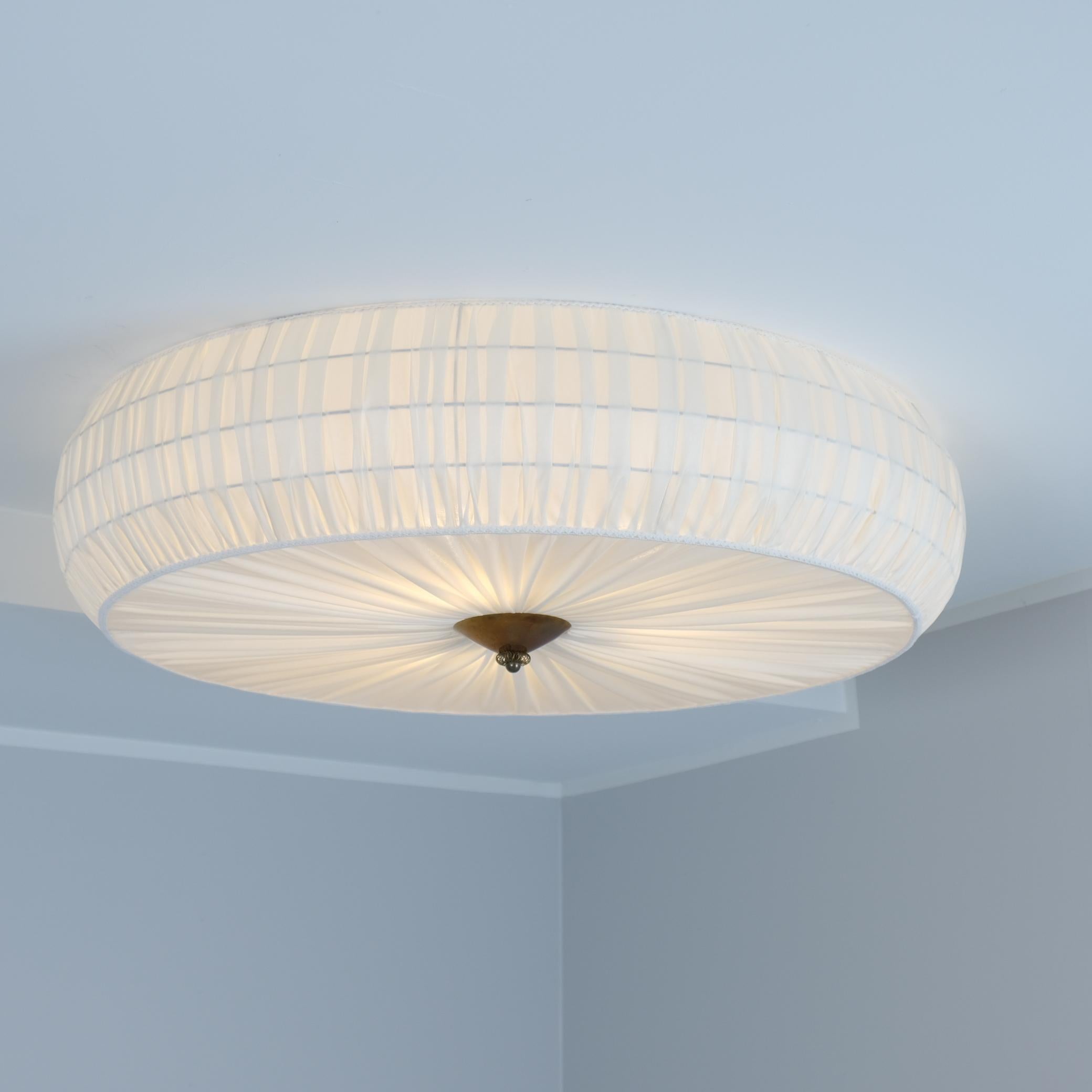 Un bellissimo e grande modello da incasso 75-204 venduto da Stockmann. La lampada è piuttosto grande e copre un'area considerevole sul soffitto aggiungendo un bellissimo elemento decorativo con la tappezzeria artistica fatta a mano che è stata