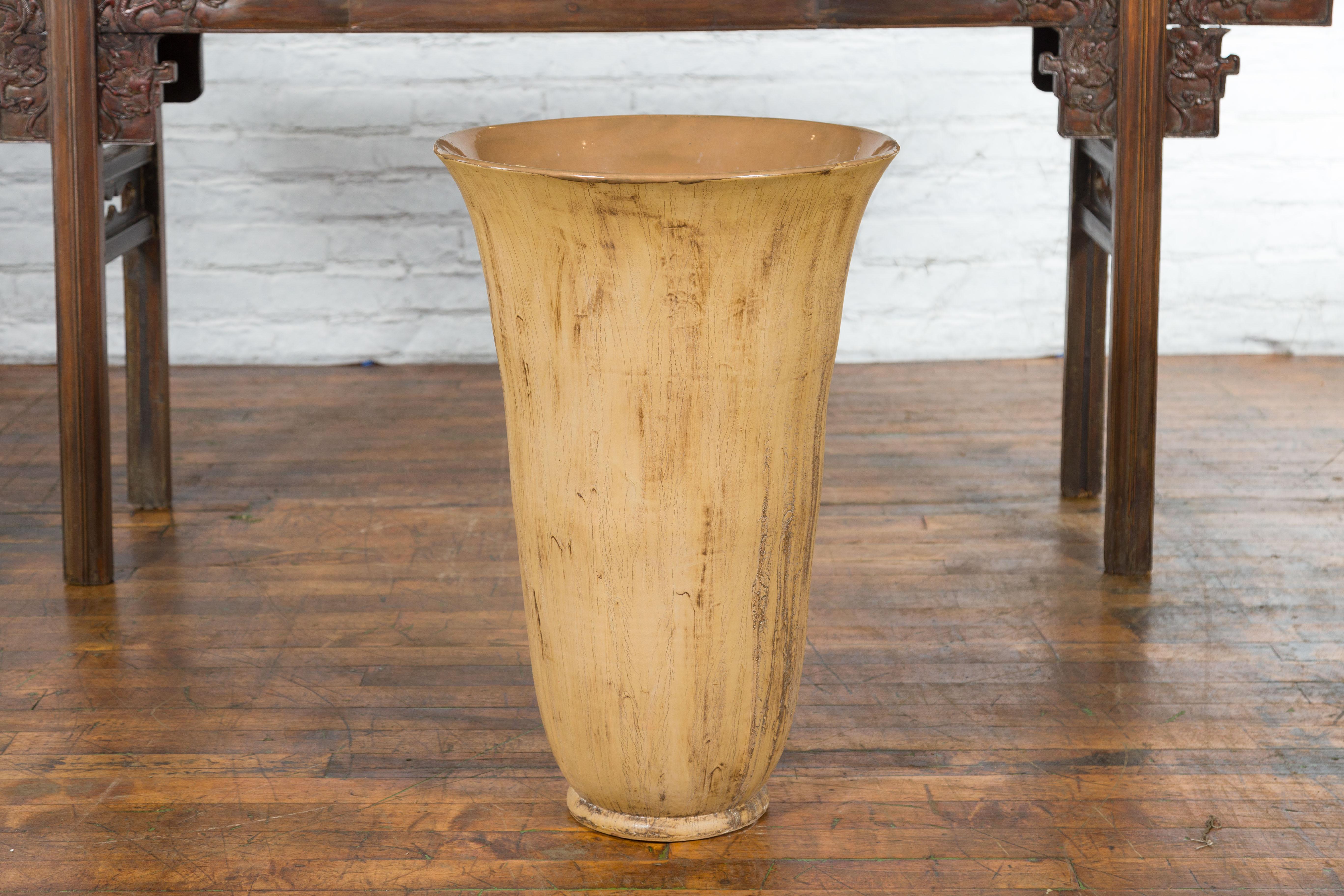 A large contemporary Thai flute shape artisan made vase with textured ground. Hand-made in Thailand, this vase captures our attention with its large proportions and flute-shaped silhouette. Showcasing an opening of 19