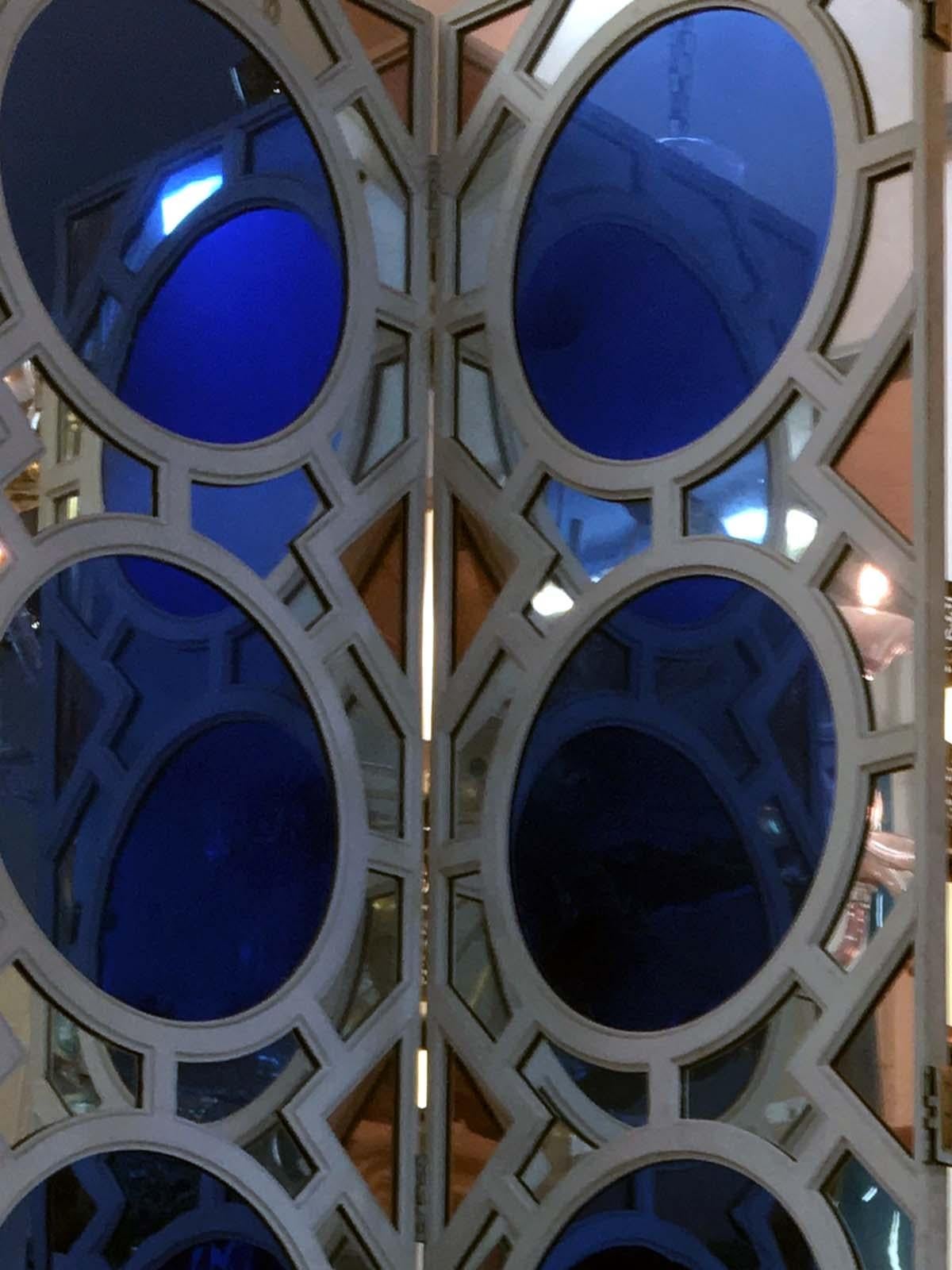 Großer und schöner Paravent mit vier Blättern, Frankreich 1970er Jahre.
Der Falzrahmen aus cremefarben lackiertem Holz ist mit Spiegelelementen, tiefblau oder farblos, ausgekleidet.
Die Rückseite ist aus lackiertem Holz.
Vier Umkehrscharniere pro