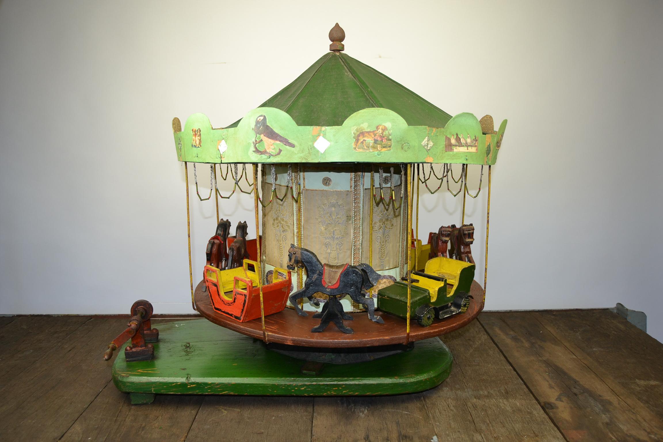 Awesome large Folk Art wooden merry-go-round model.
This large scale model of a Carousel or Roundabout has been handmade.
Great example of Carnival Art - Folk Art with miniature handmade wooden sculptures of horses, jeep cars and sleigh. All very