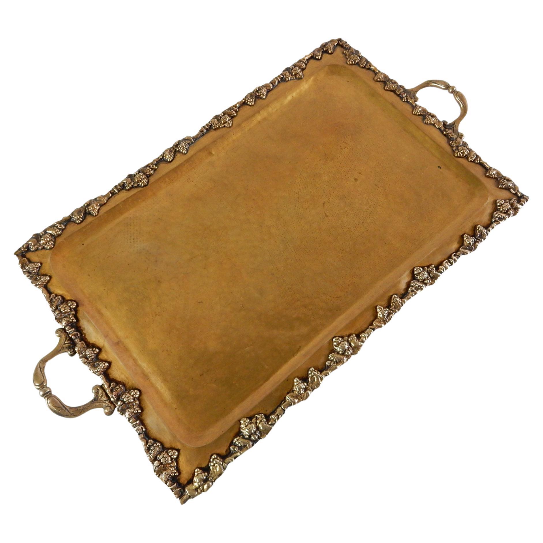Exceptional brass handled footed tray for service or use for bar.
Hammered tray with grapevine trimmed edge.
Large piece measuring 31in long x 17in wide x 2in tall.
Warm aged patina throughout. It's fabulous!
Shipped within 48 hours or purchase.