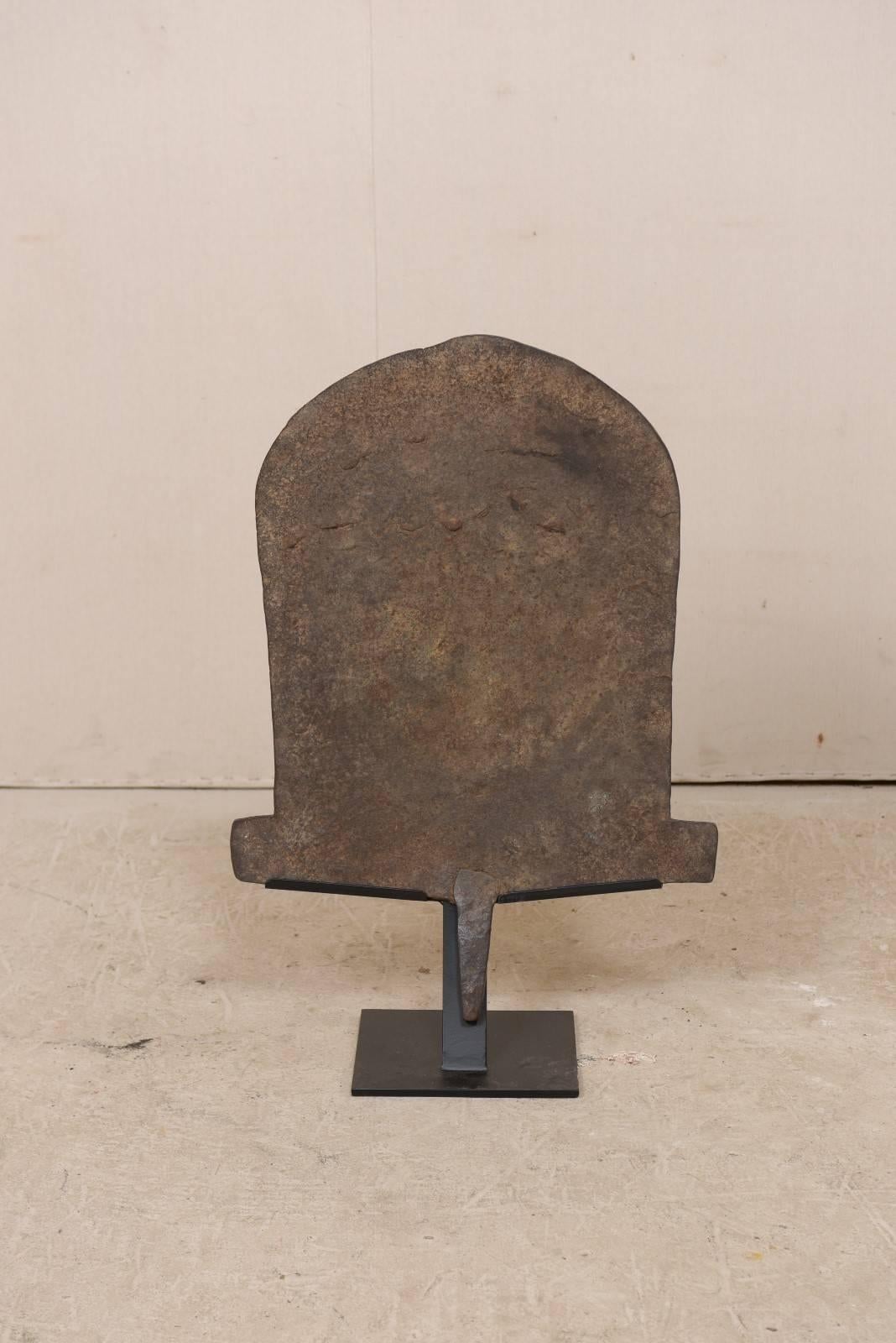 A large specimen of African iron money currency from the early 20th century on custom stand. This antique iron monetary piece is often referred to as 