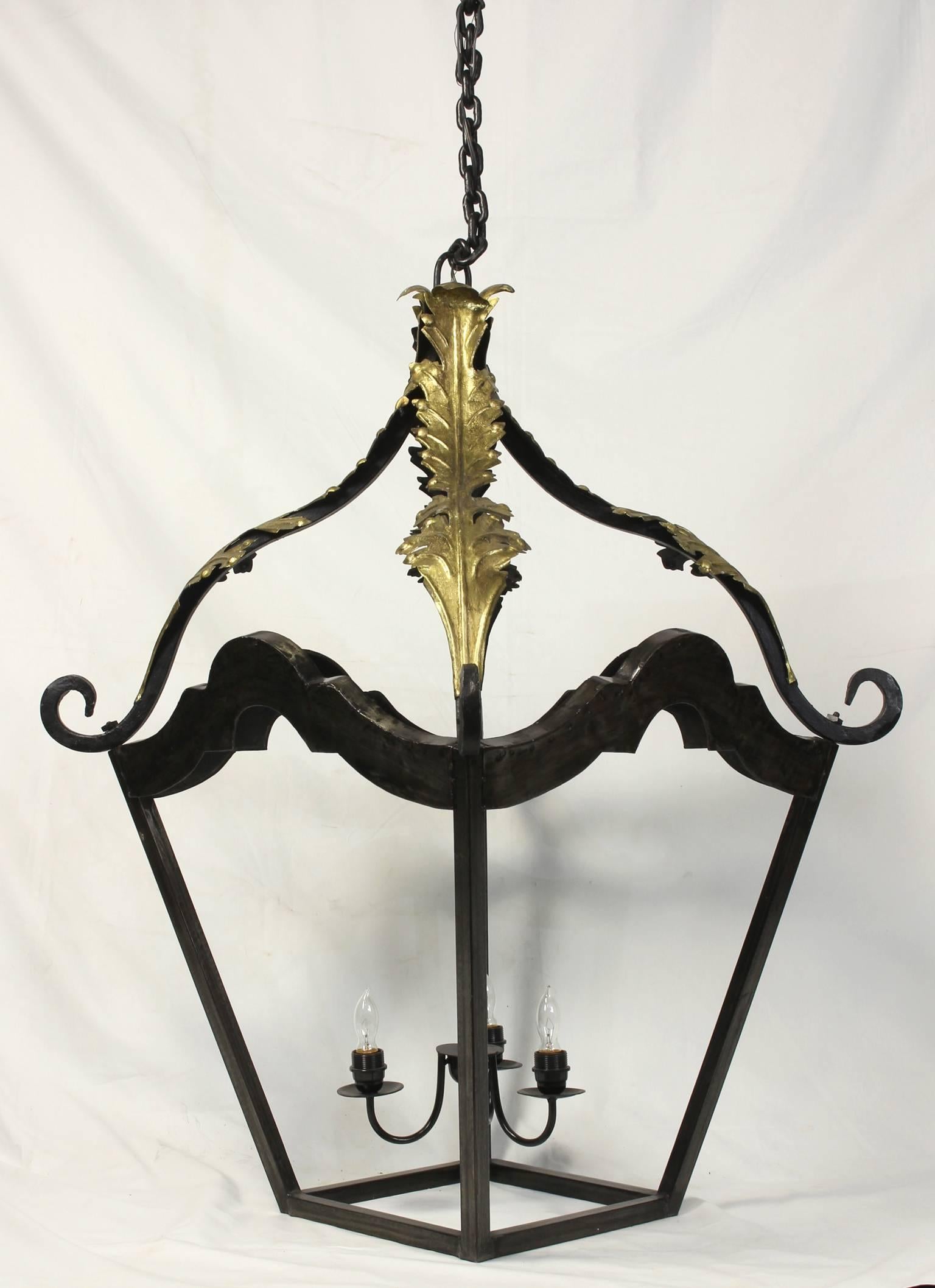 A massive French style forged metal hanging lantern accented with gold acanthus leaf accents.