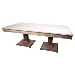 Grande tavolo da pranzo con base a piedistallo in stile formale, dorato in argento e con piano in vetro