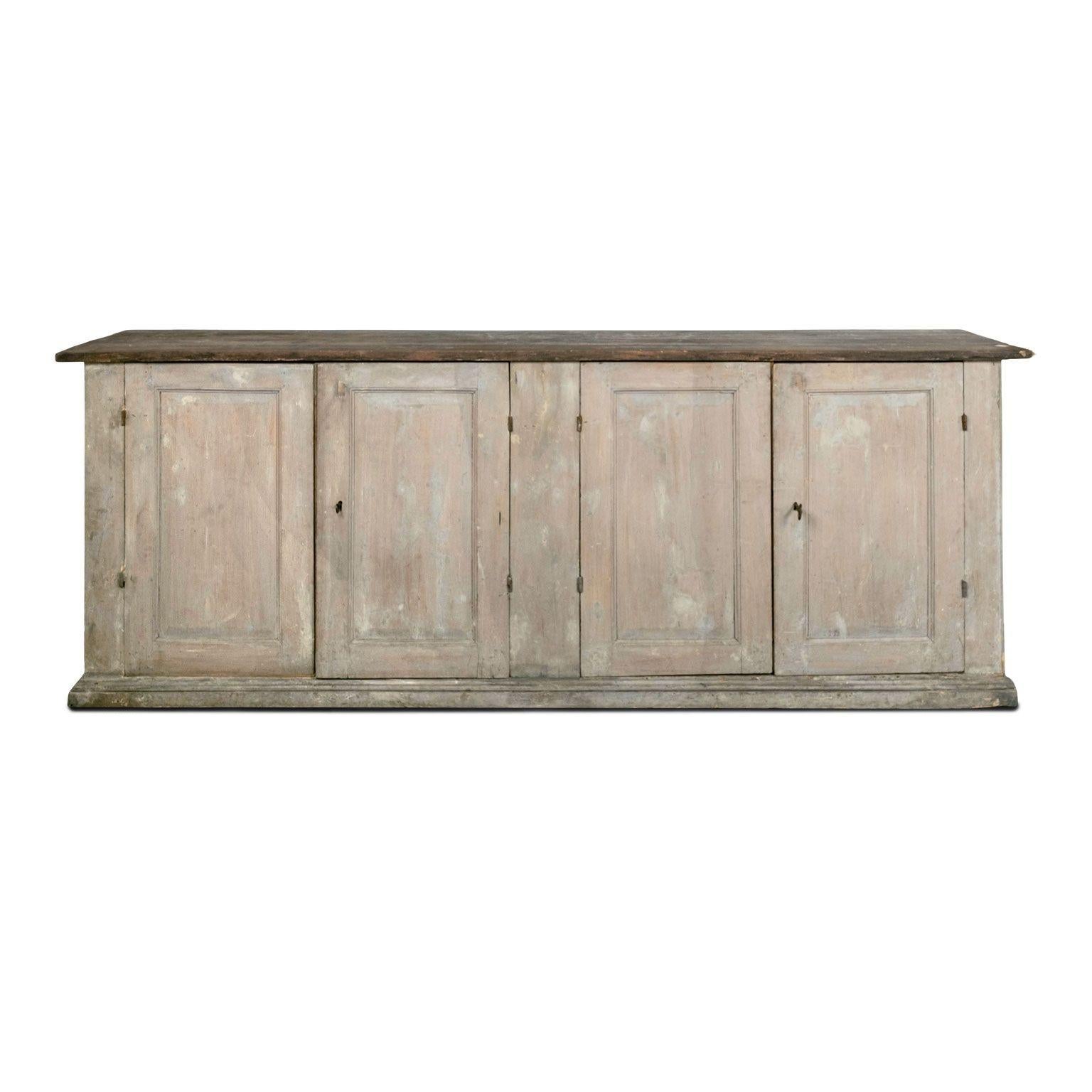 Large four-door painted enfilade, circa 1850-1889, France. Large rustic French enfilade buffet with gray painted with warm salmon color undertones. Large rustic wooden top. Surface edges are smoothed and rounded from centuries of natural wear and