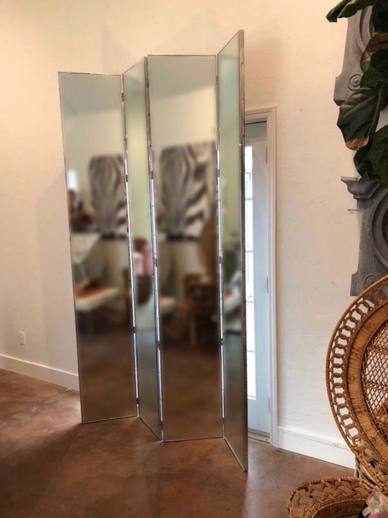 Beautiful and large mid-century modern four panel mirrored screen in great vintage condition. This screen has wonderful impact in making a room look larger, or dividing a space. it is currently being displayed in two sections, but hinge together in