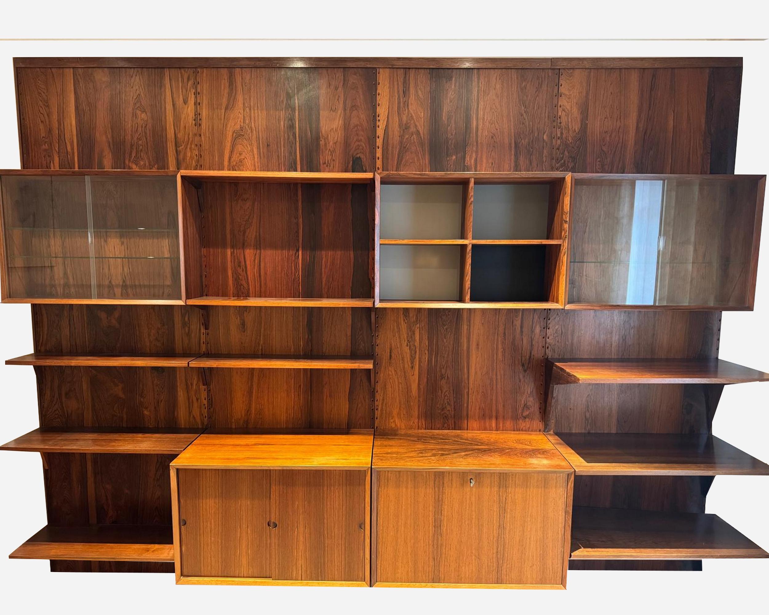 Cado shelving system by Poul Cadovius in Brazilian rosewood, composed of:

– 4 rack panels: H 248 cm (97.6 in) x W 80 cm (31.5 in) x D 5 cm (1.97 in).
– 1 cabinet with 4 compartments, blue-gray and black background: H 56 cm (22 in) x W 80 cm (31.5