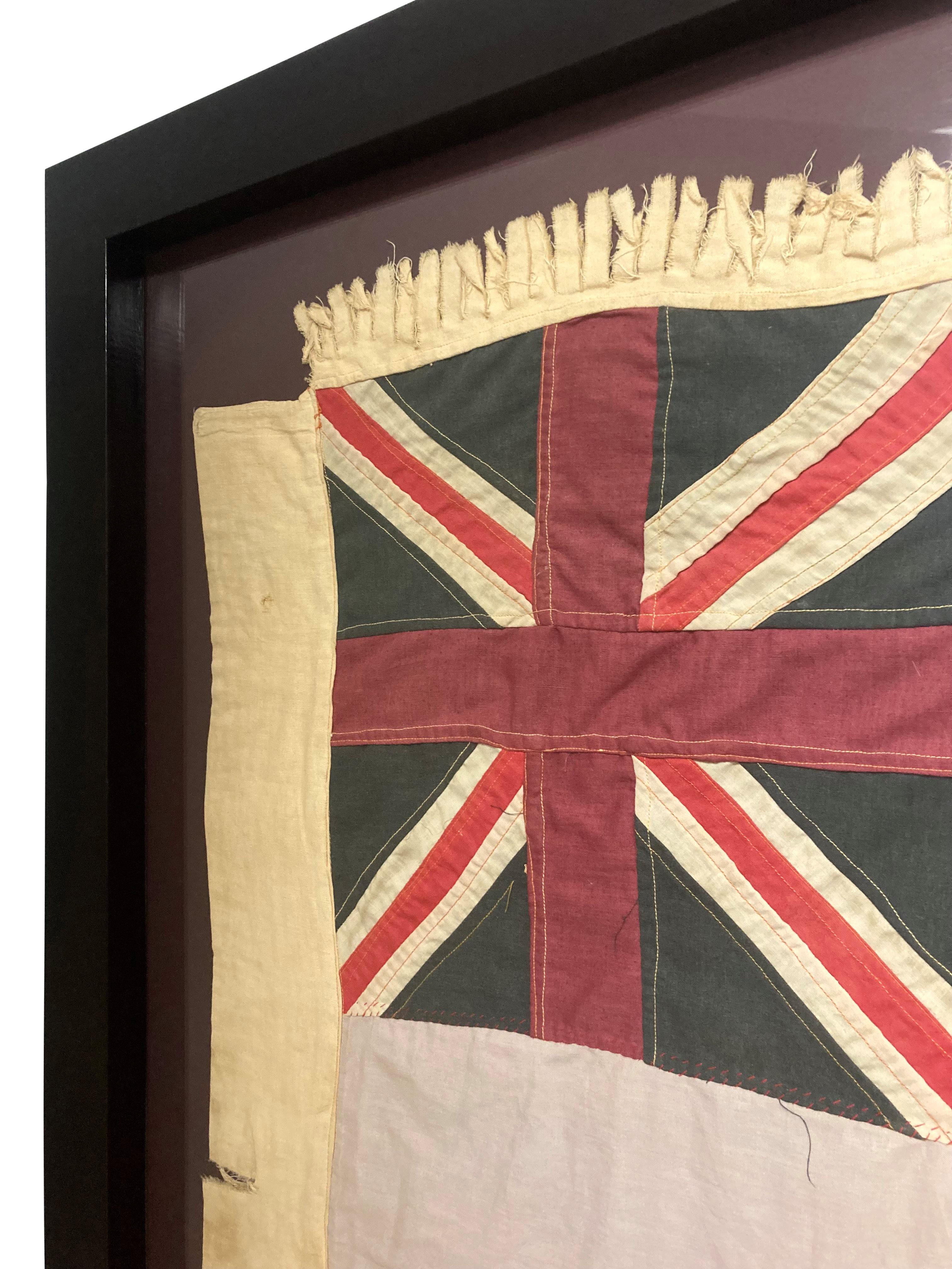 Un grand drapeau Fante Asafo ghanéen cousu à la main, dans un cadre en noyer foncé. Représentant l'Union Jack, un lion central, entouré de quatre trèfles.