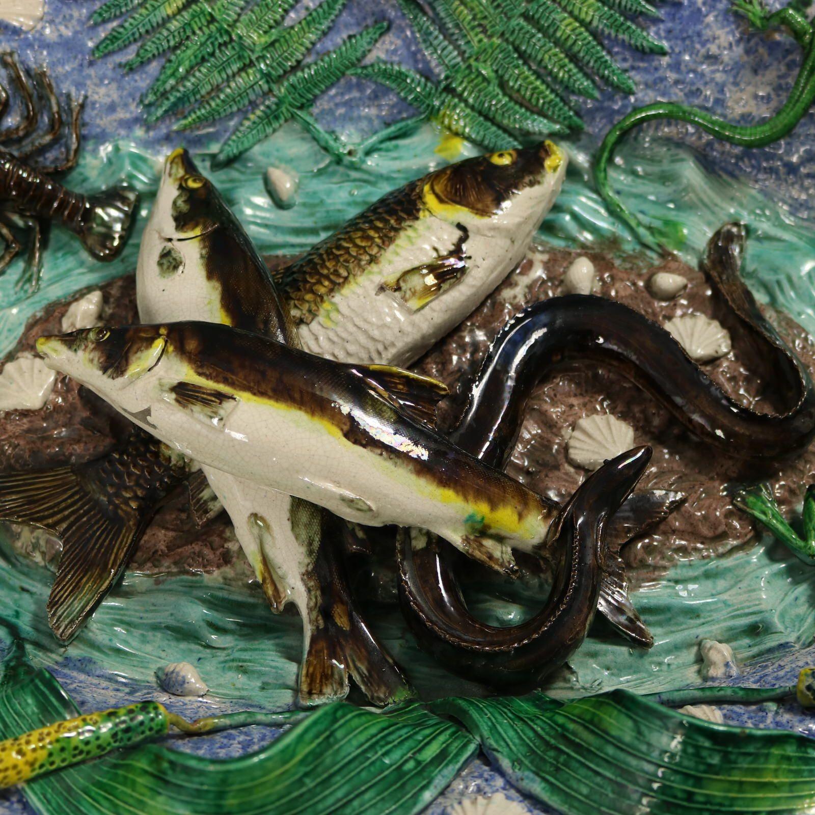 Francois Maurice Französisch Palissy Majolika Wandteller, die drei Fische und ein Aal in der Mitte zeigt. Auf dem Teller sind Muscheln, ein Frosch, eine Schildkröte, eine Eidechse, eine Schlange, eine Languste, Käfer, Farnblätter, Lilienpads und