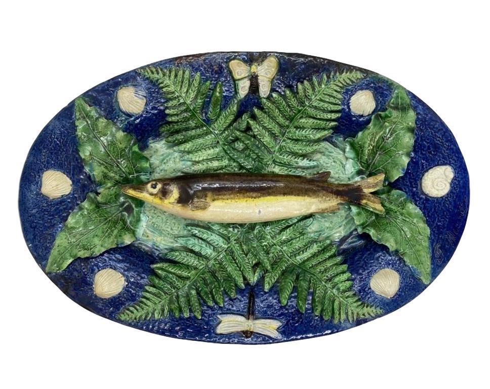 Large Franҫois Maurice Palissy Ware Majolica Trompe L'oeil Fish Plaque, Paris, circa 1880, signed with impressed signature, 'F. Maurice.' Naturalistically molded and applied, with a central fish on a bed of green glazed leaves and ferns, with