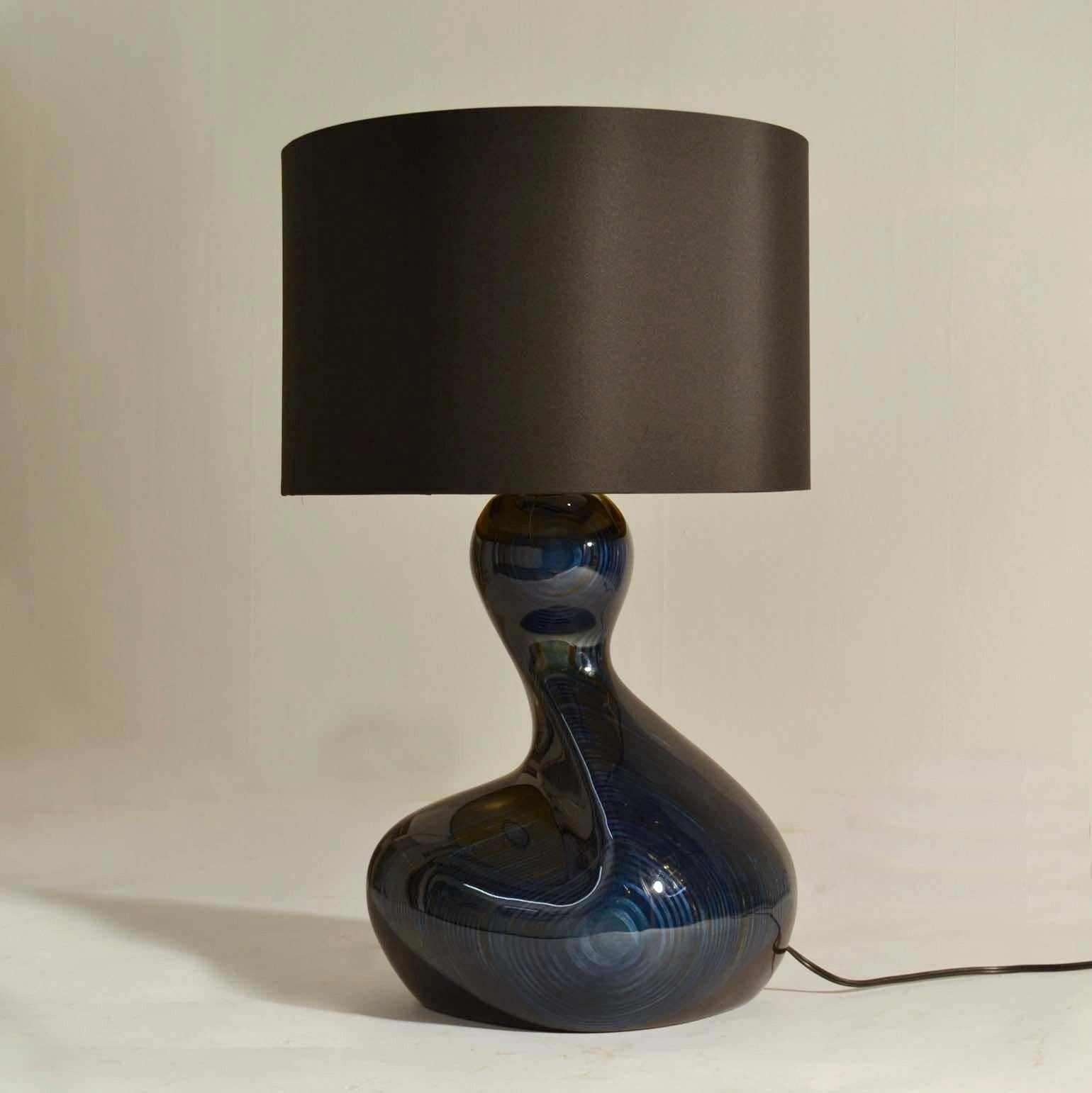 Free form sculptural table lamp in deep blue wood with black shade by Chris Wallis 2000, no 26 of a limited edition. The base is sculpted out of a solid plywood stained and lacquered which reveals the layers in an organic way like yearrings of a
