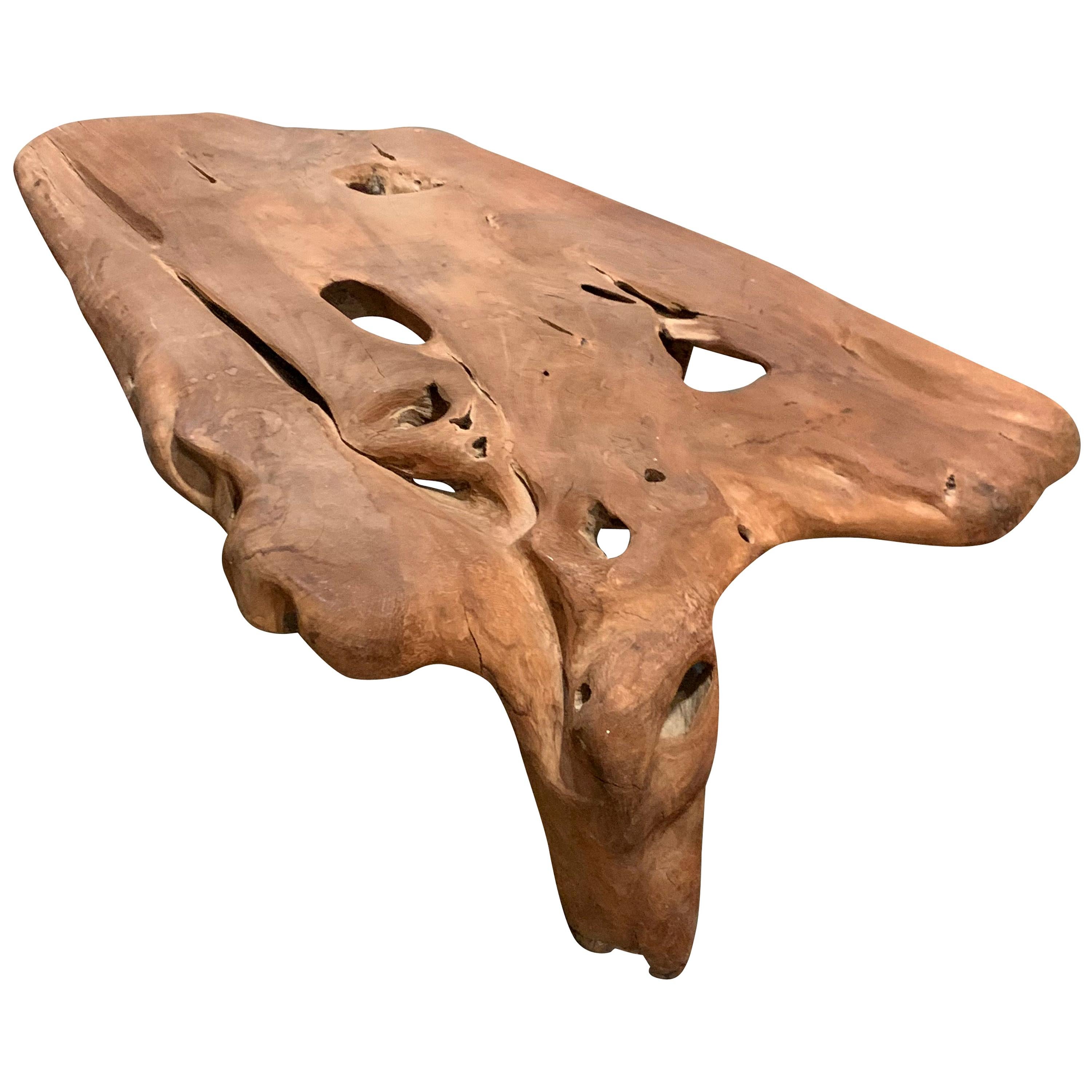 Indonesian large freeform organic shape coffee table is made of teak.
The top has a smoothed surface and sits on three legs.
The natural patina enhances the beauty of the table.