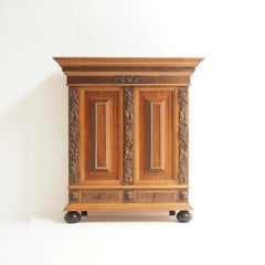 Large, freestanding armoire made of oak with ebony colored colegs and details