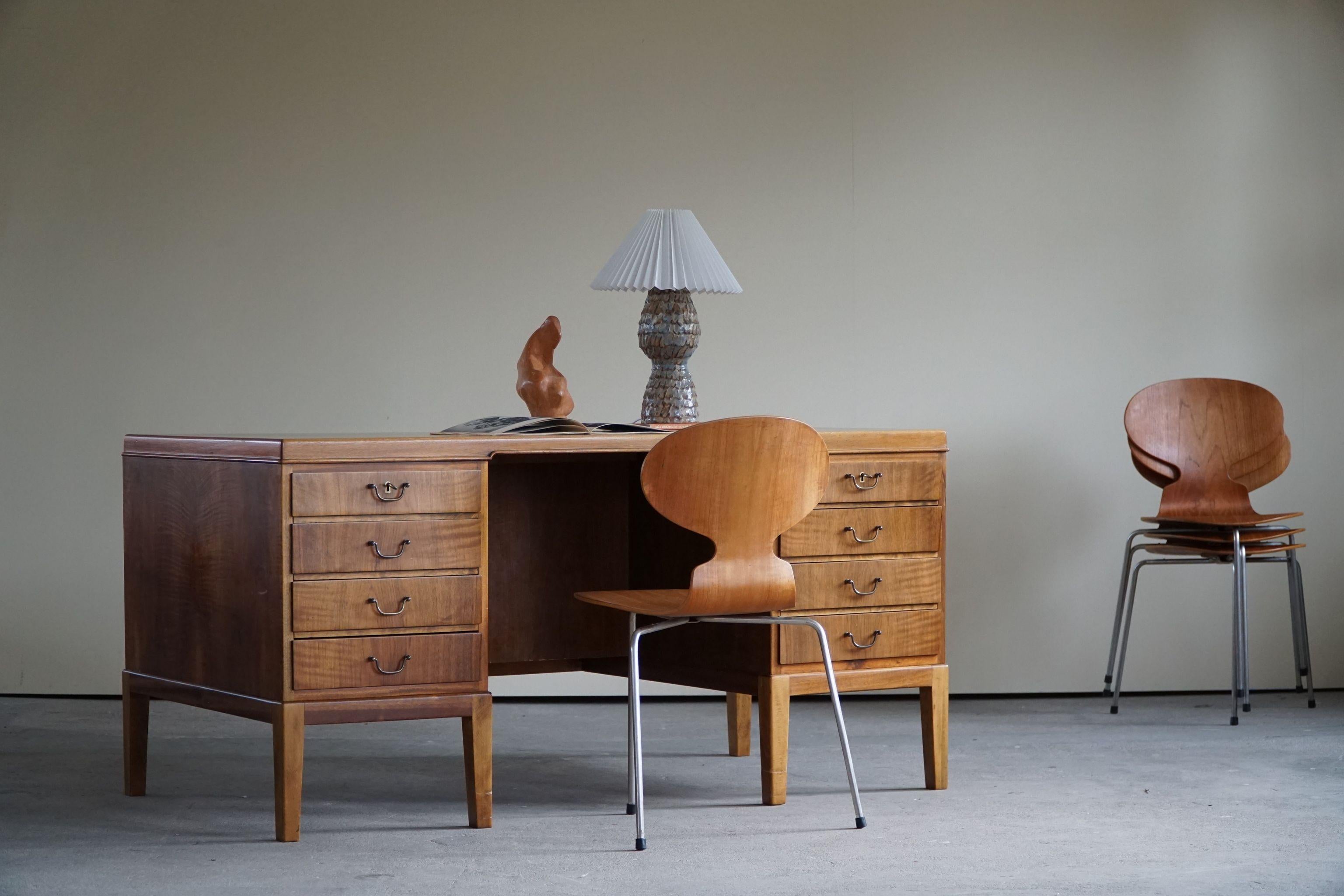 Large Freestanding Danish modern office desk in walnut, with brass handles. Made in 1940s.
Attributed to Danish architect Ole Wanscher.

A beautiful classic piece in a great vintage condition.