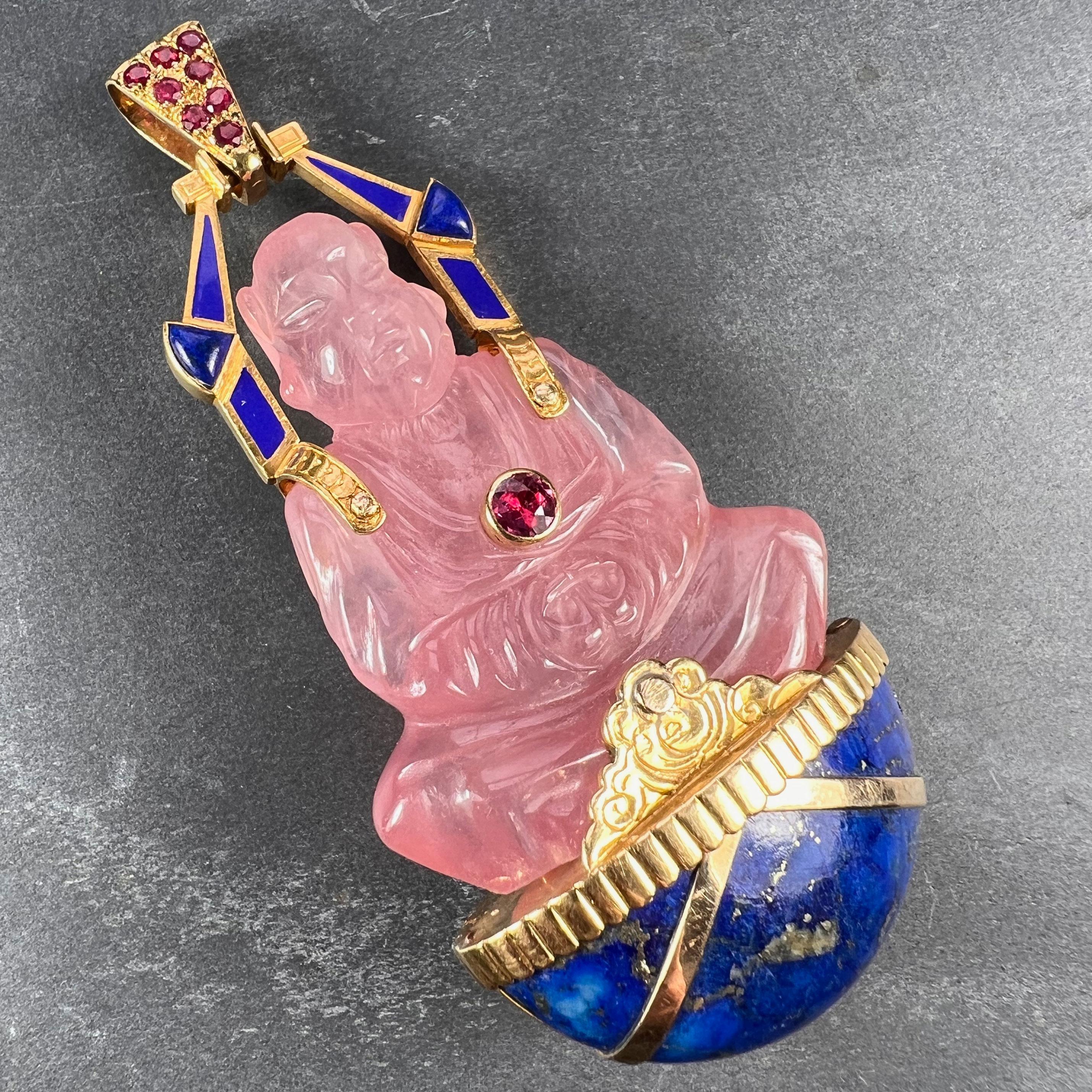 A large French 18 karat (18K) yellow gold pendant designed as a carved rose quartz Buddha sitting in prayer on a cabochon of lapis lazuli, set with rubies to the pendant bail and chest. Stamped with the eagle's head for French manufacture and 18