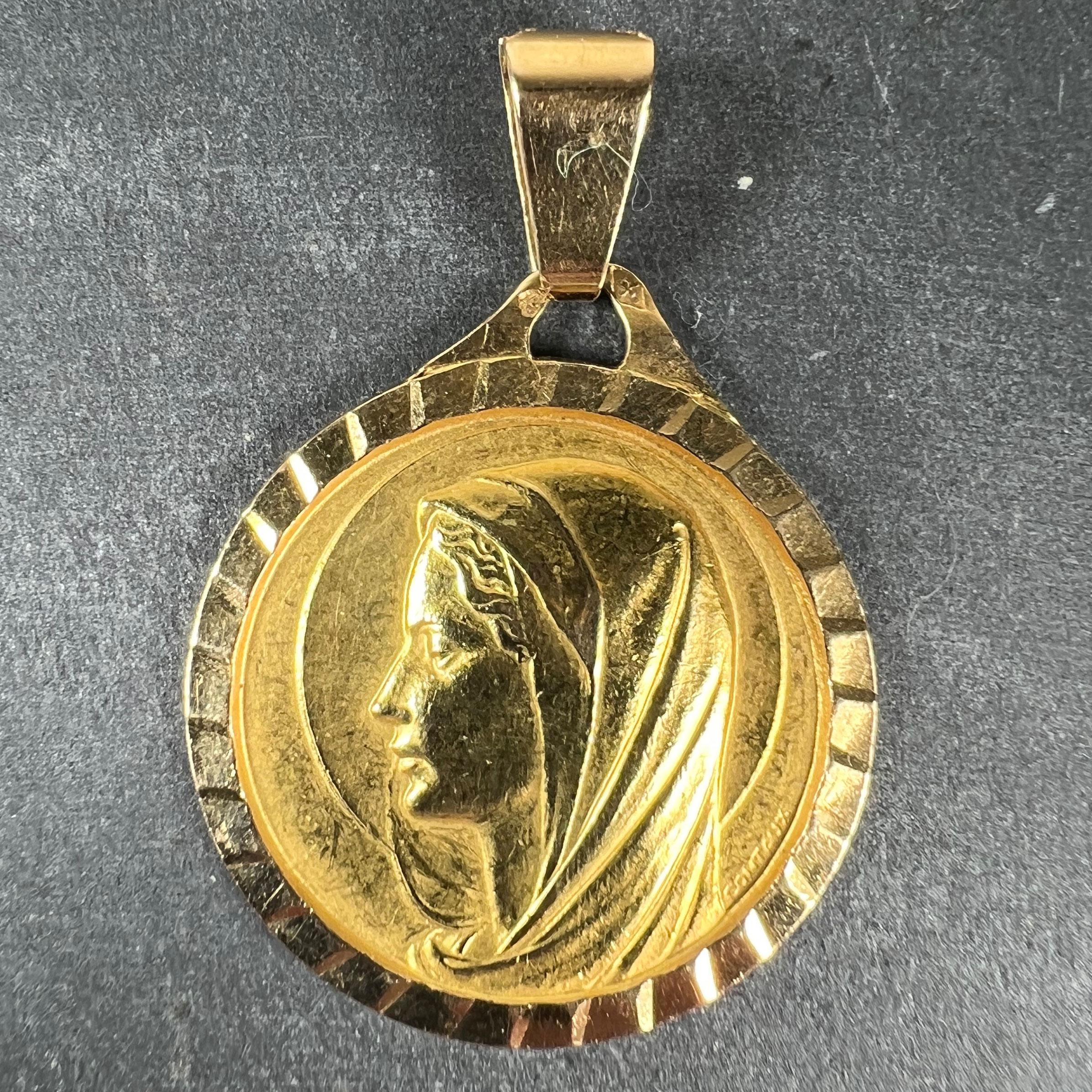 A large French 18 karat (18K) yellow gold charm pendant designed as a medal depicting the Virgin Mary in profile with a halo. Signed Contaux. Stamped with the French eagle’s head for 18 karat gold and an unknown maker’s mark.

Dimensions: 2.7 x 2.4