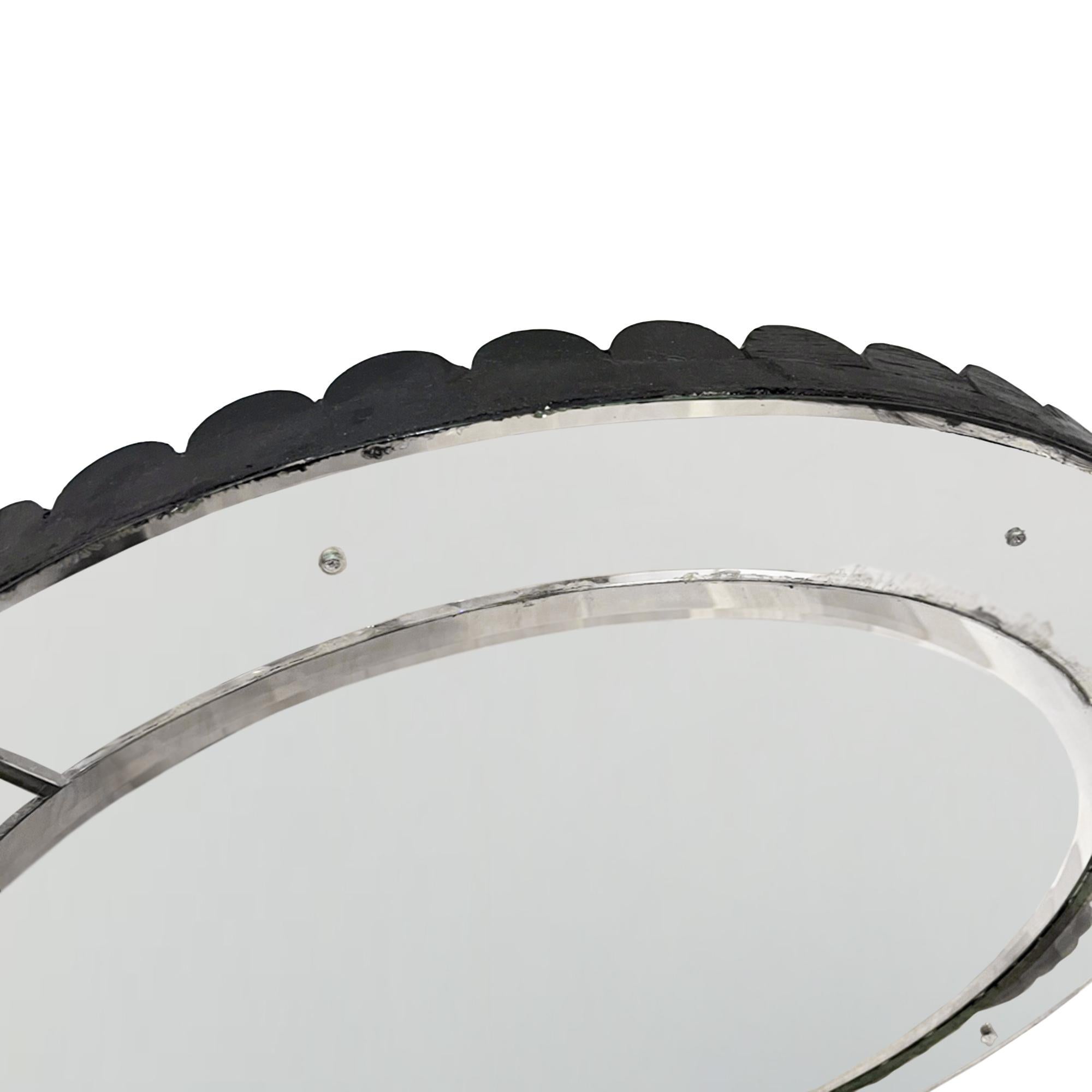 This is an unusal round mirror with a four sectioned border and an ebonised scalloped edge. 

With a bevelled border and small flower pins the mirror design is simple but elegant. 

A great addition to any room, this is a decorative and practical