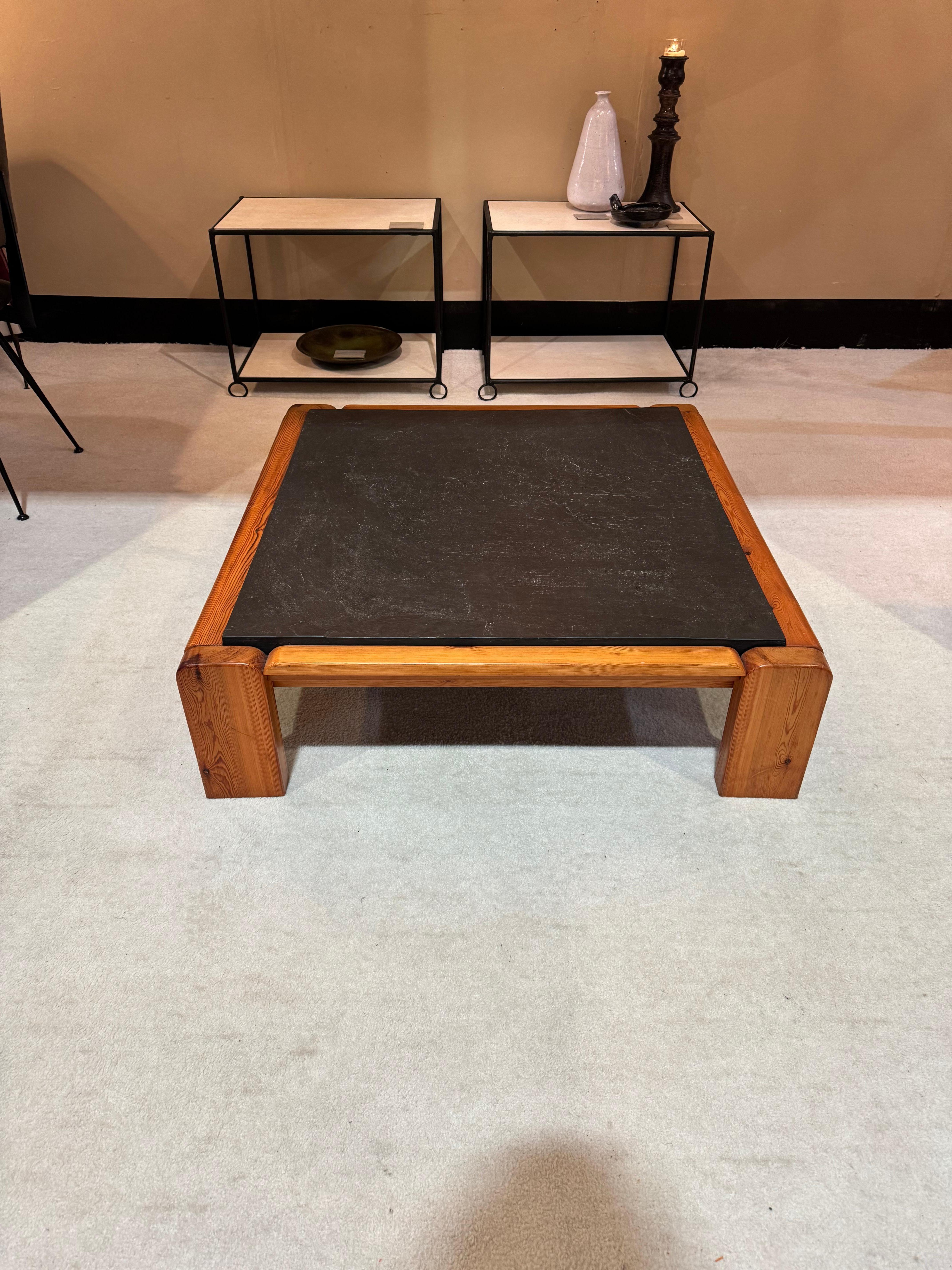 Une table basse en pin massif et au plateau en ardoise épaisse, aux lignes courbes élégantes. Une pièce d'exception. 