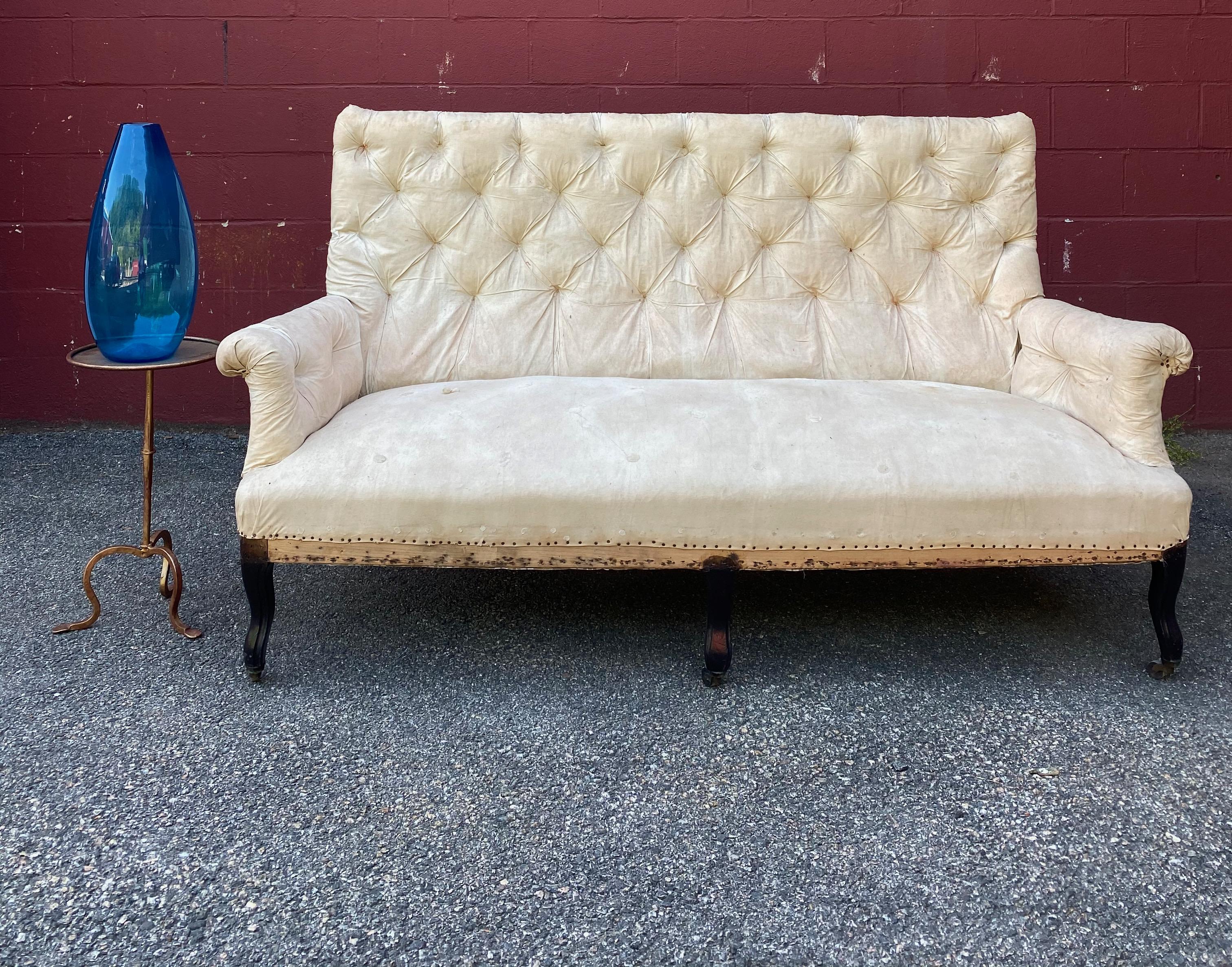 Large scale Napoleon III sofa with cabriole legs. The back is heavily tufted as are the rolled arms. The sofa has been stripped down to the muslin and is ready to be upholstered. 
French, late 19th century.
Dimensions: 70” W x 30” D  x 39” H (15”