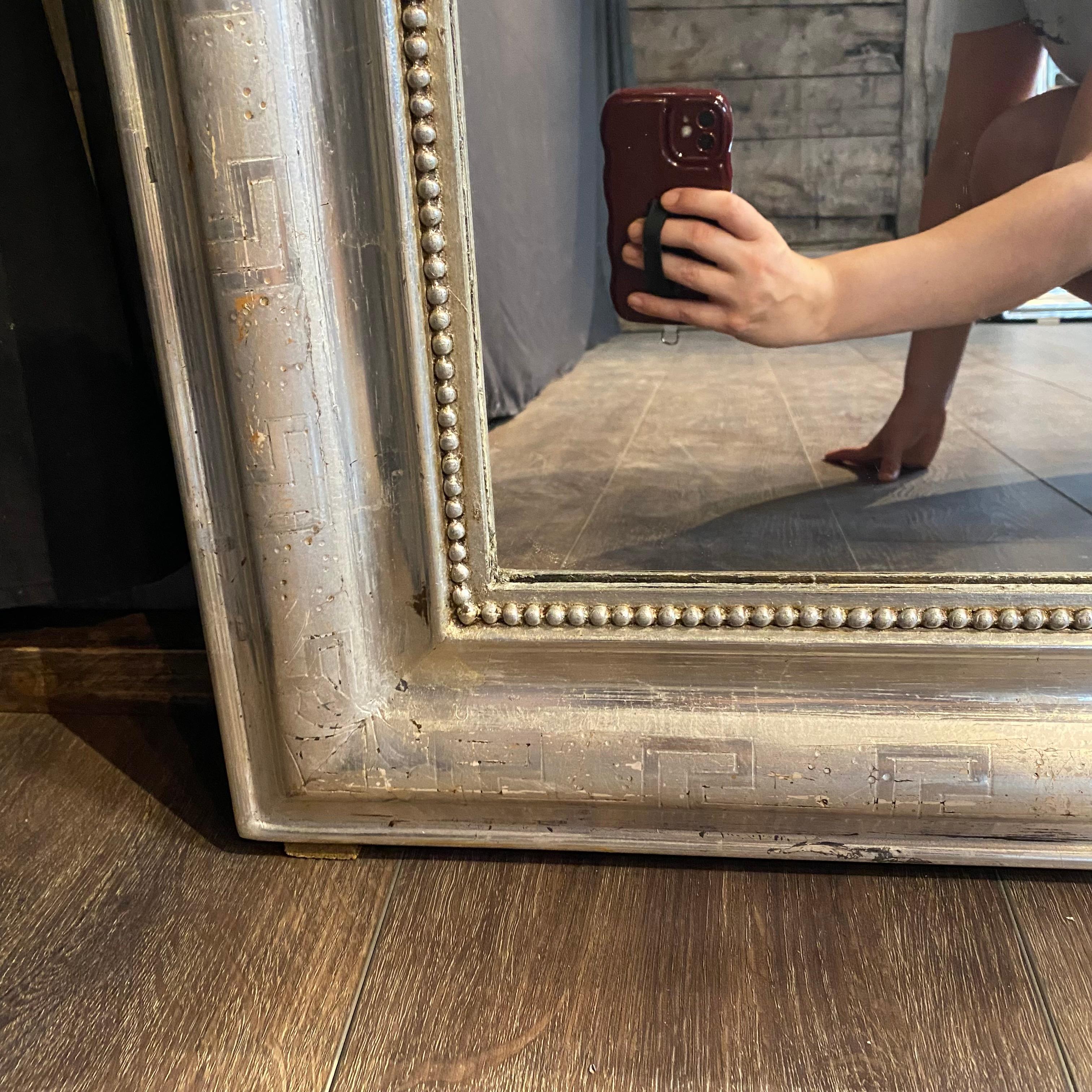 Fine French silver Louis Philippe mirror with lovely beading, and the silver-gilt frame of this original Louis Philippe mirror is meticulously inscribed with a Greek key pattern along the bullnose of the frame. The satin texture is subtle and