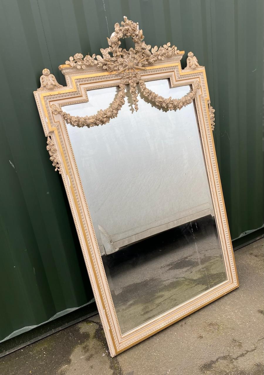 A truly wonderful large French wall or floor standing mirror. Dating to the 19th century and made from wood with gesso and original finish. Having original bevelled mirror plate and lovely floral swags. A few very minor losses as can be seen but in