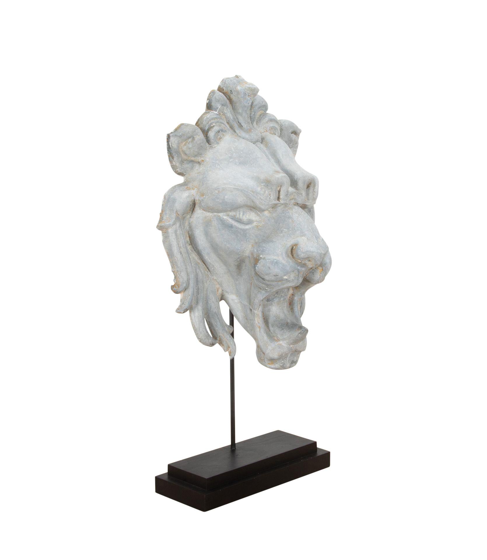 Large French 19th Century lion head in zinc.  Once would have decorated a facade, with time weathered patina. Circa 1850. Measurements are inclusive of the wooden base.